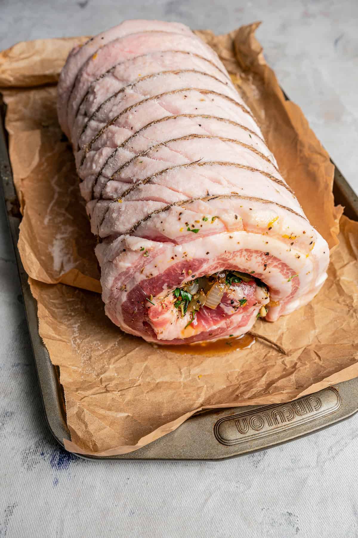 Prepared porchetta on a parchment-lined baking sheet.