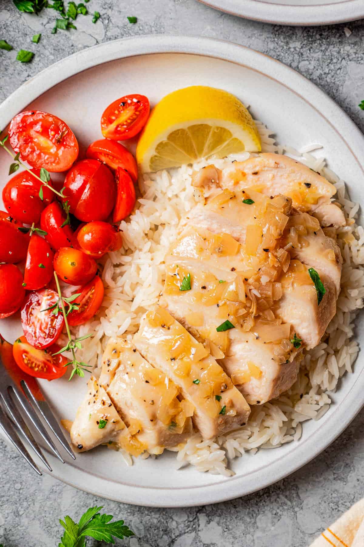 Chicken breast, sliced and served with rice and halved cherry tomatoes.