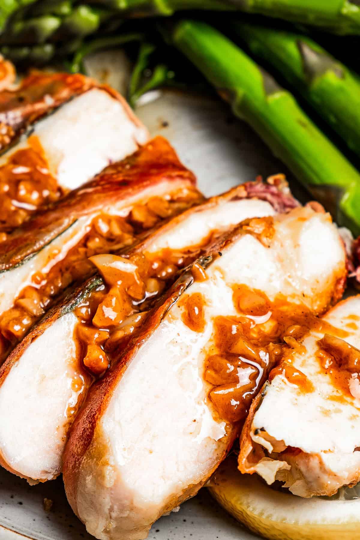 Sliced chicken breast with a drizzle of sauce over the slices.