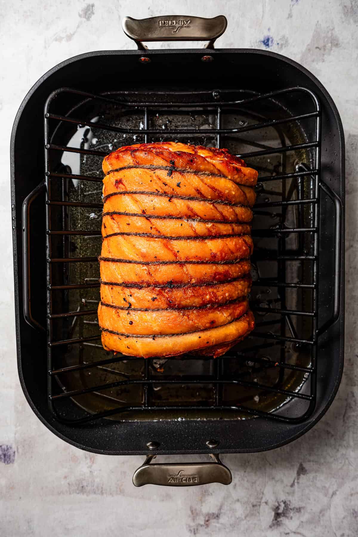 Overhead view of cooked porchetta in the roasting pan.