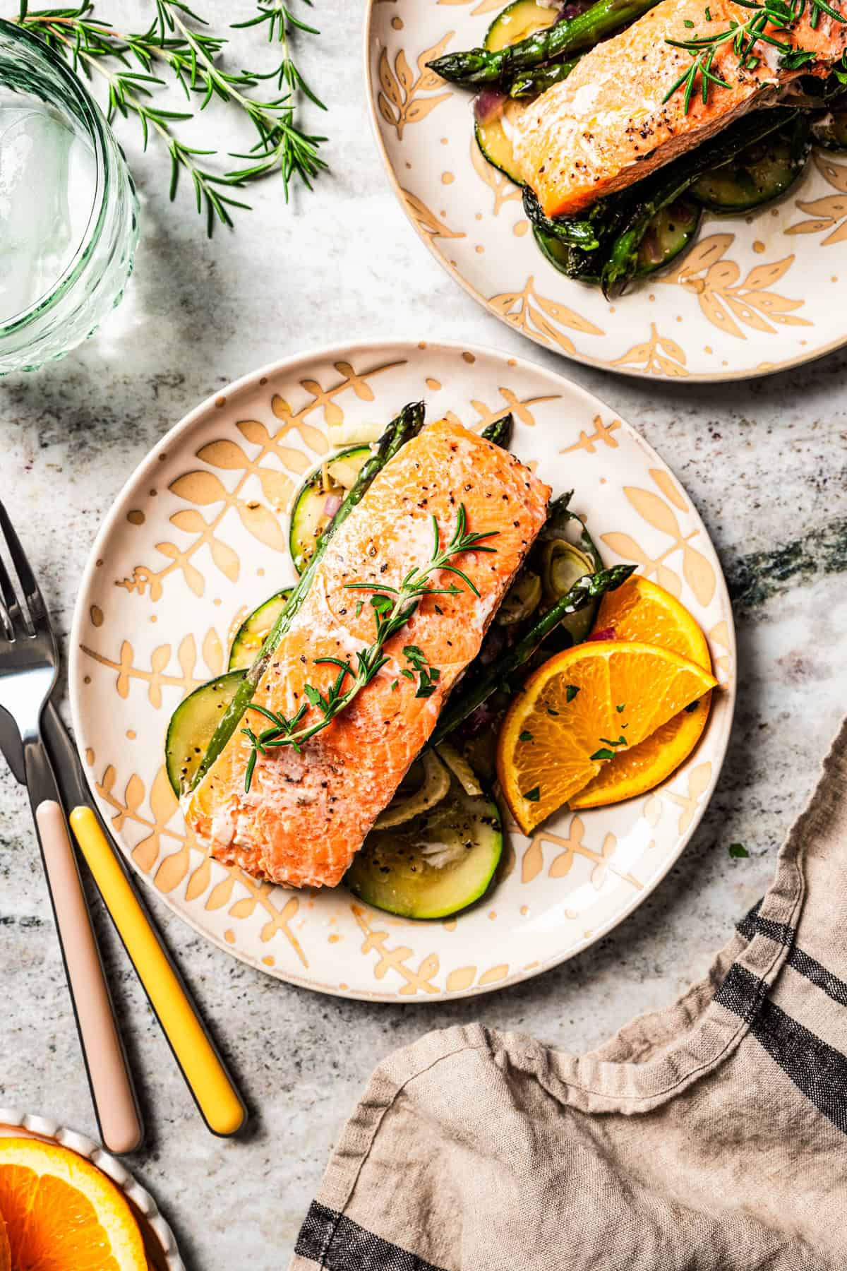 Overhead image of salmon fillets served on two dinner plates.