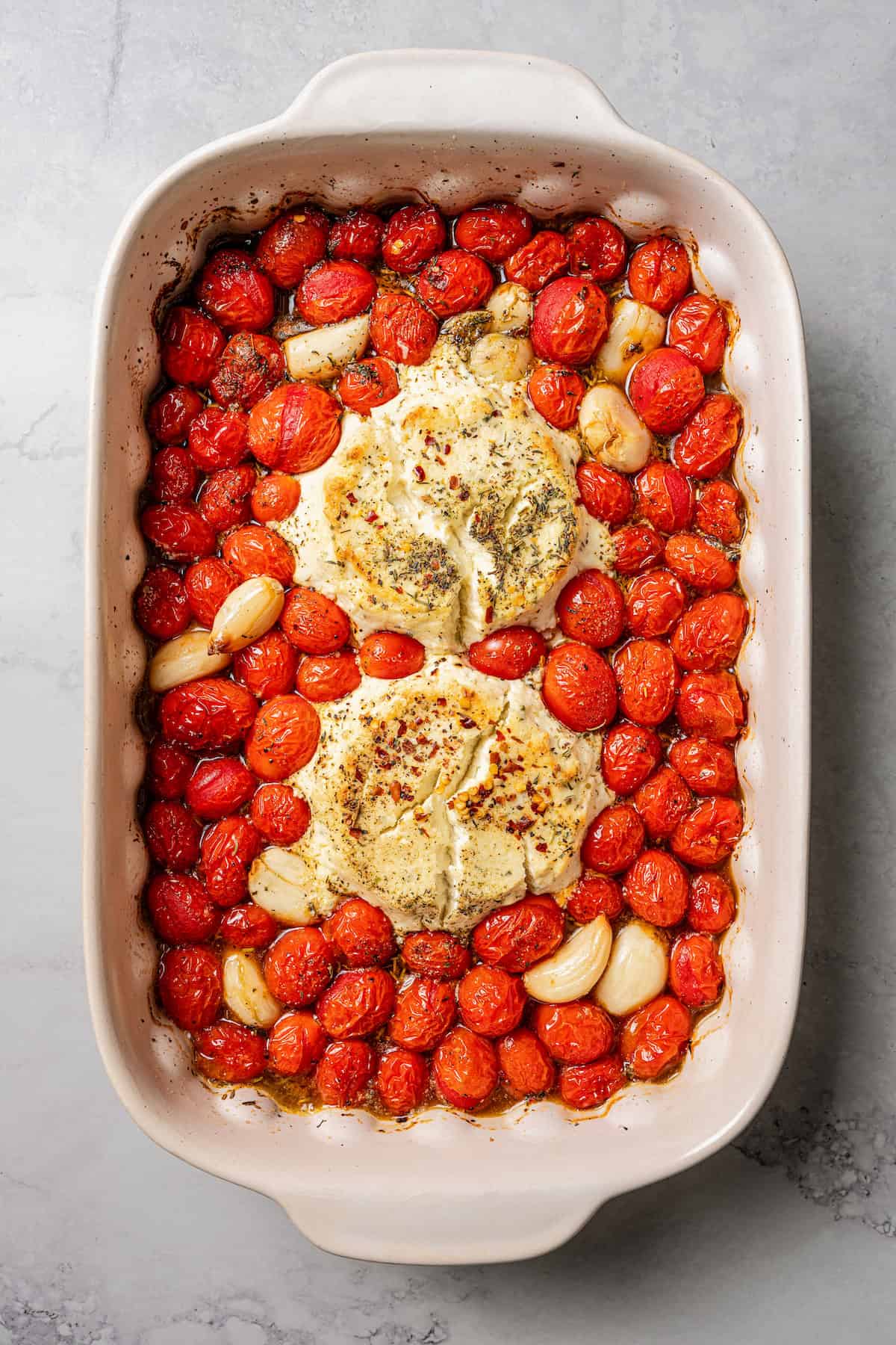 Roasted tomatoes, garlic, and Boursin cheese in a baking dish.