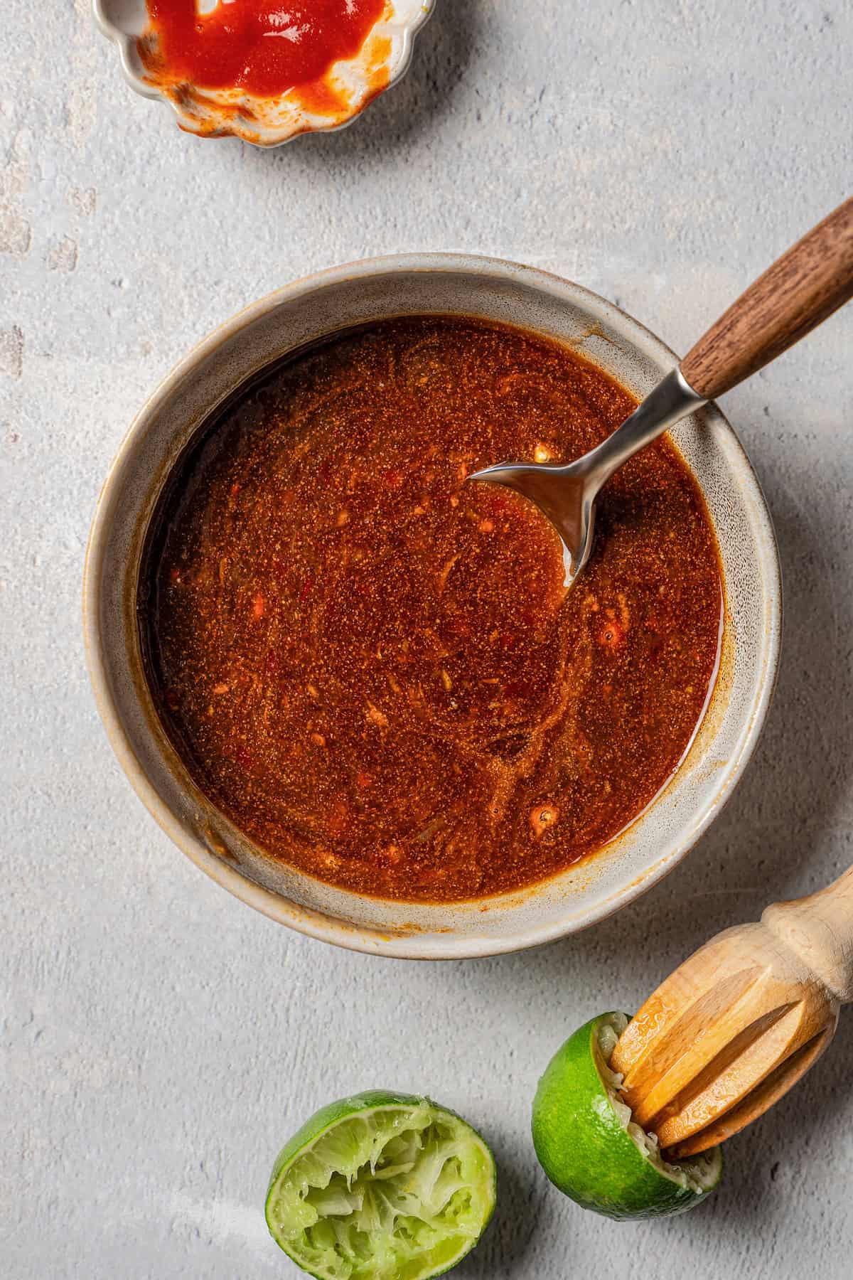 Overhead view of firecracker shrimp sauce in a bowl with a whisk.