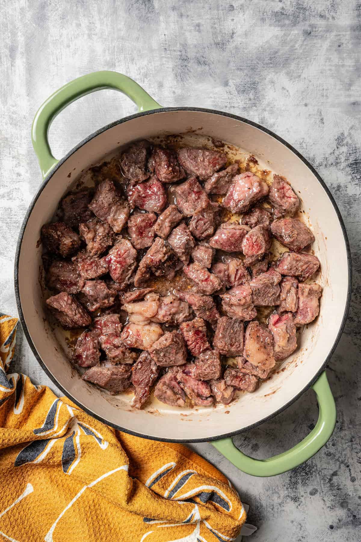 Seared beef cubes in a large pot.