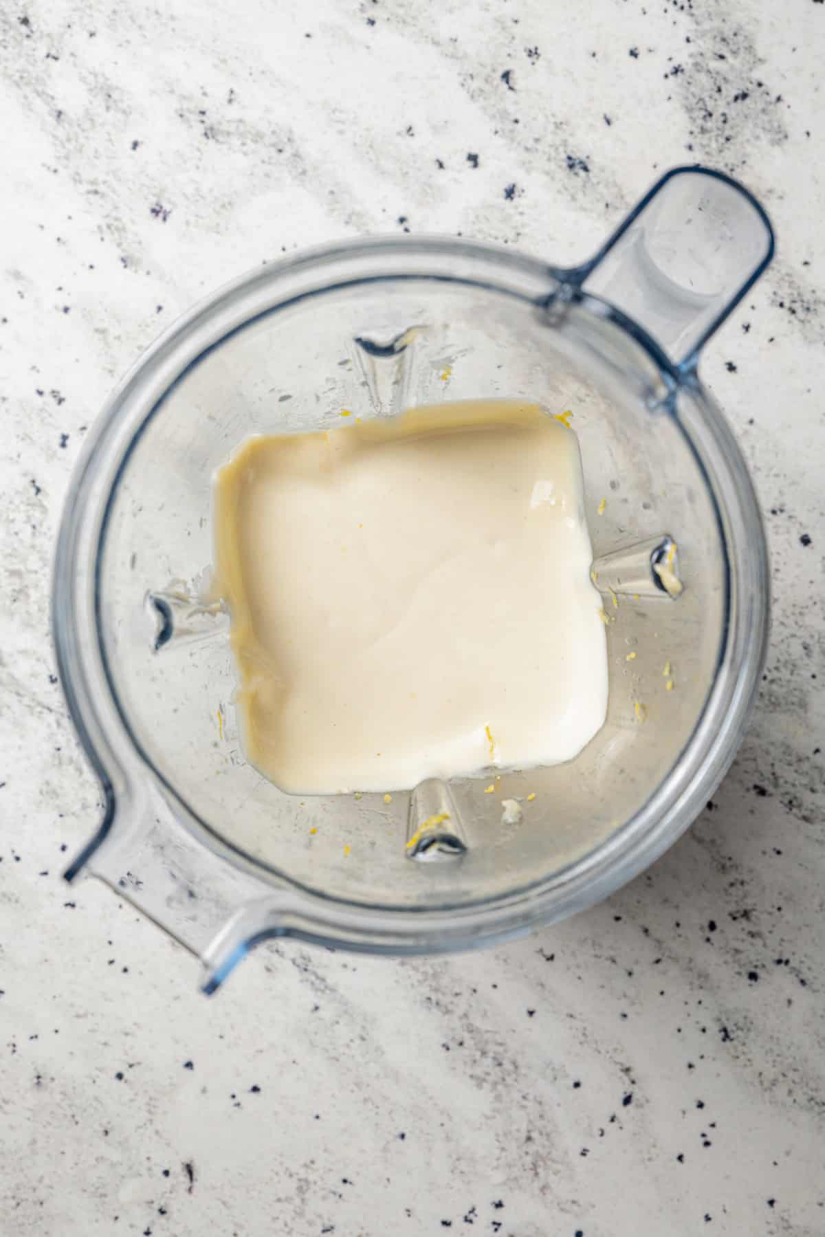 Overhead view of roasted garlic aioli in a blender.