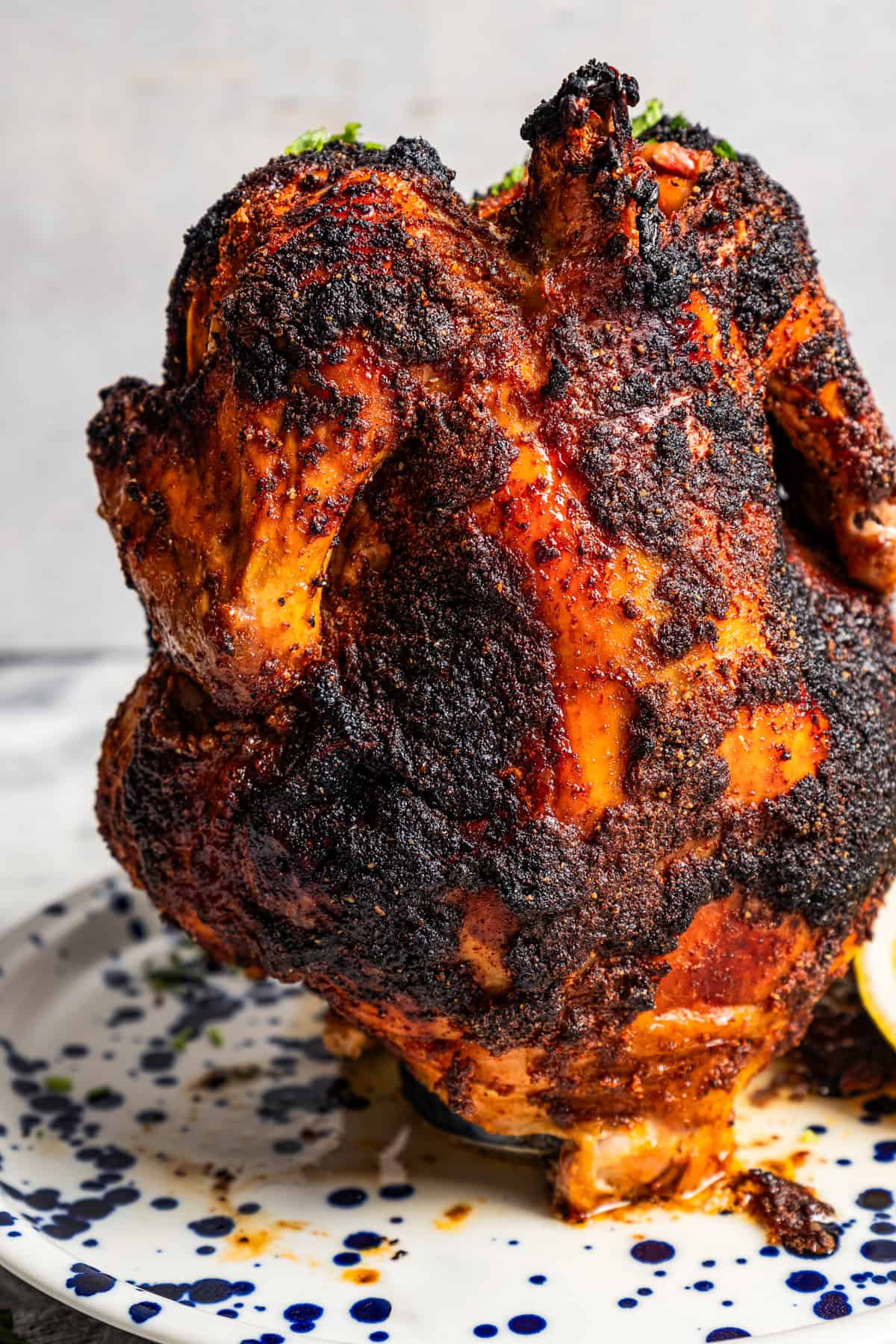 Whole cooked chicken sitting over a beer can.