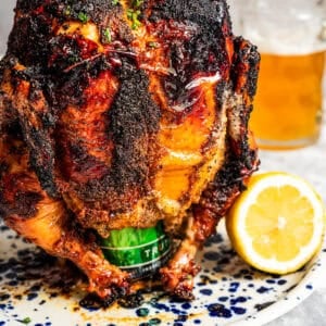 Whole cooked chicken propped up over a beer can.