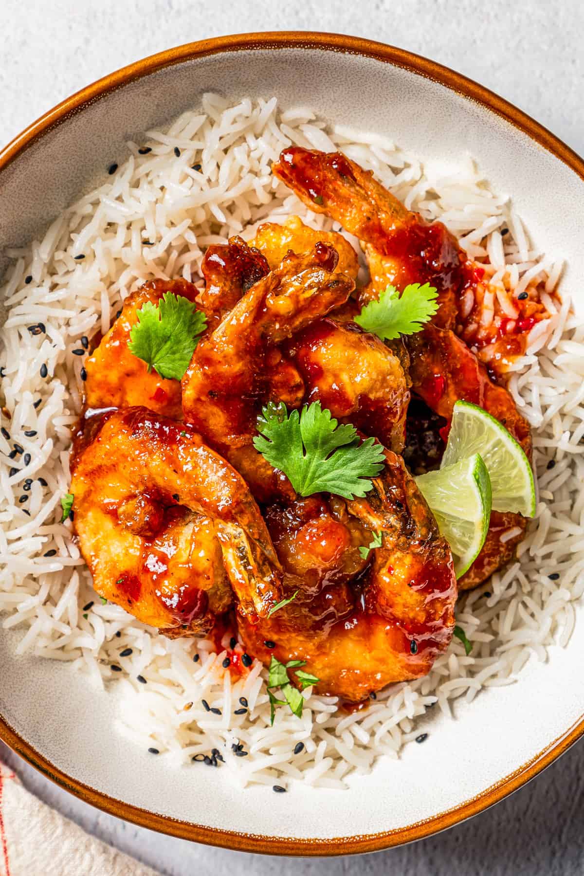 Firecracker shrimp served over rice in a bowl.