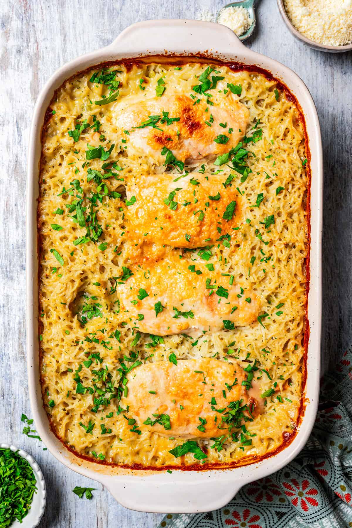 Baked no peek chicken and rice in a casserole dish and garnished with chopped parsley.