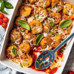 Breaded shrimp parmigiana arranged in a baking dish.