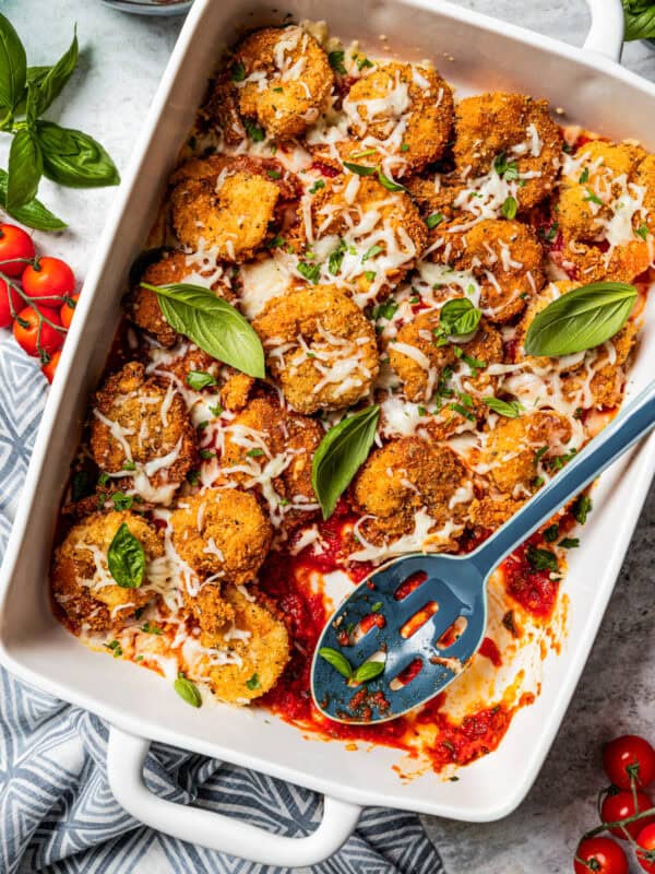 Breaded shrimp parmigiana arranged in a baking dish.