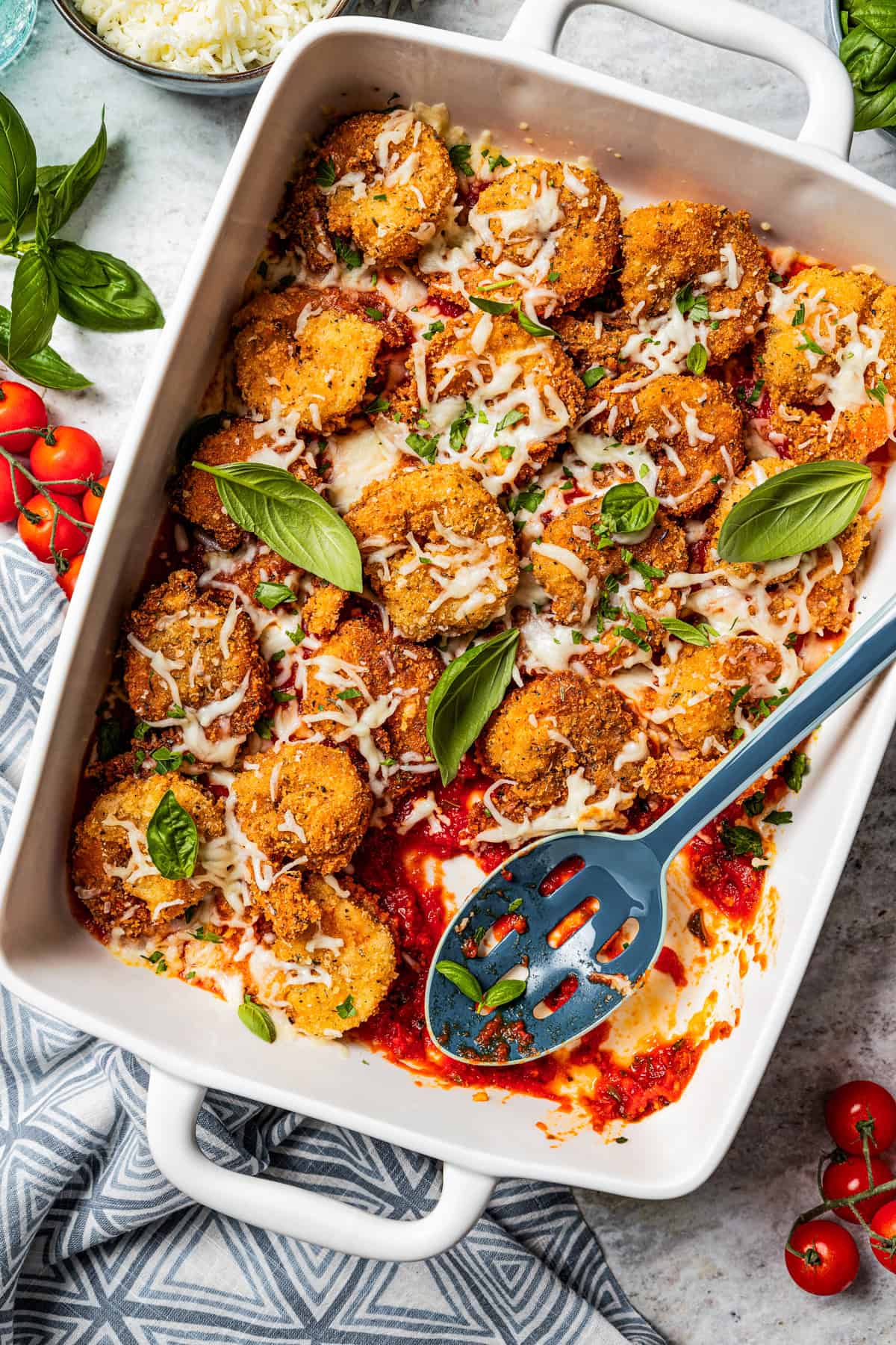 Breaded shrimp parmigiana arranged in a baking dish.