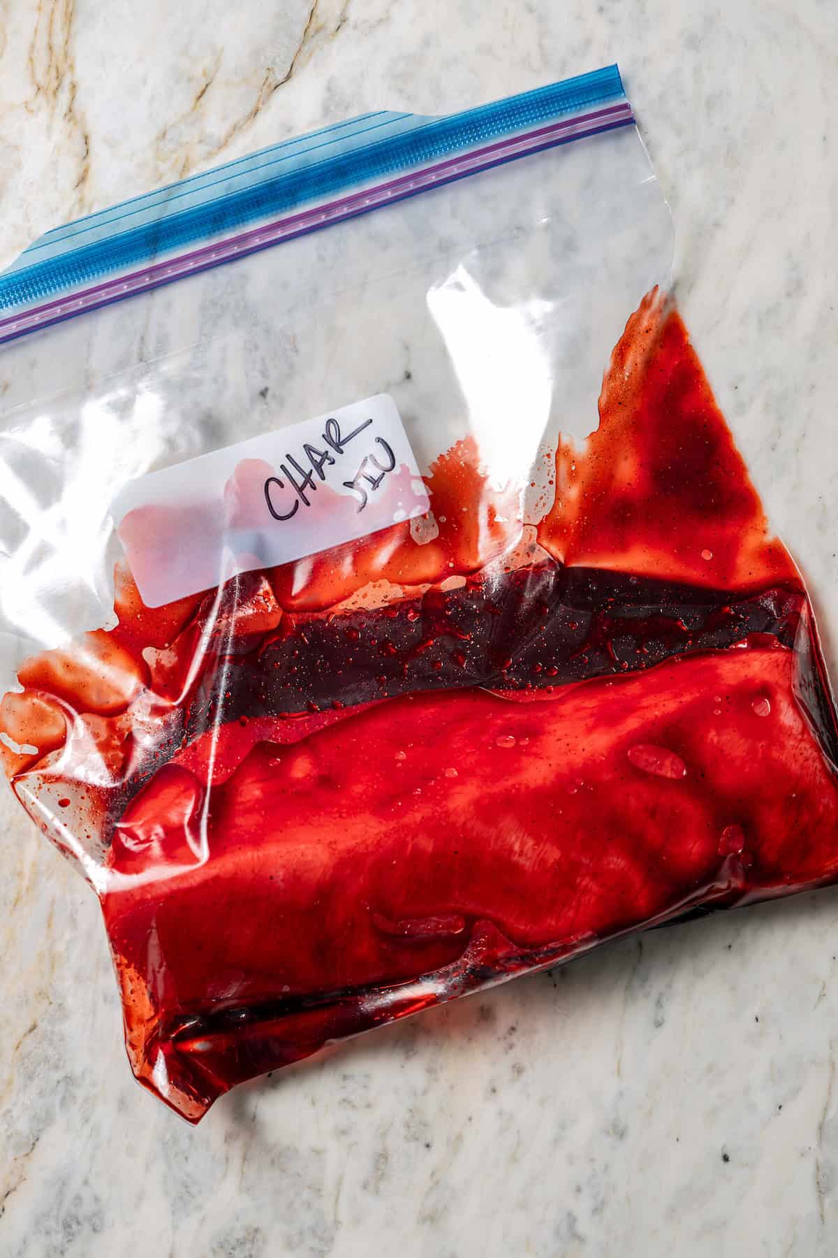 Pork tenderloin marinating in a Ziploc bag.