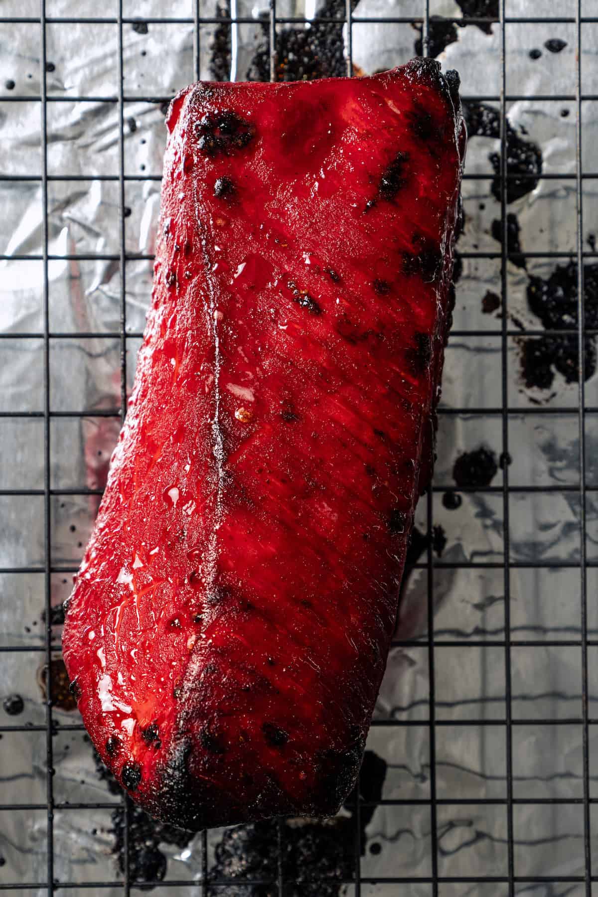 Overhead view of char siu on a wire roasting rack.