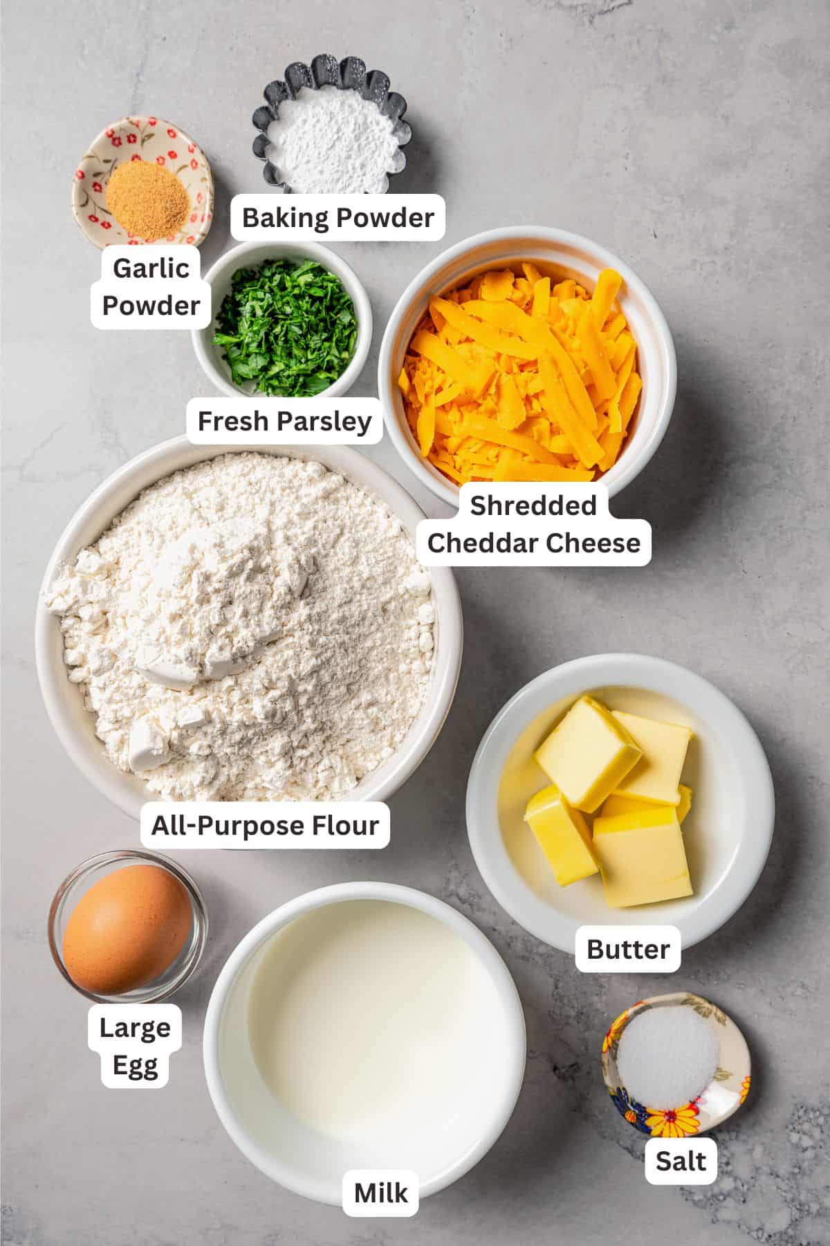 Ingredients for cheddar bay biscuits with text labels overlaying each ingredient.