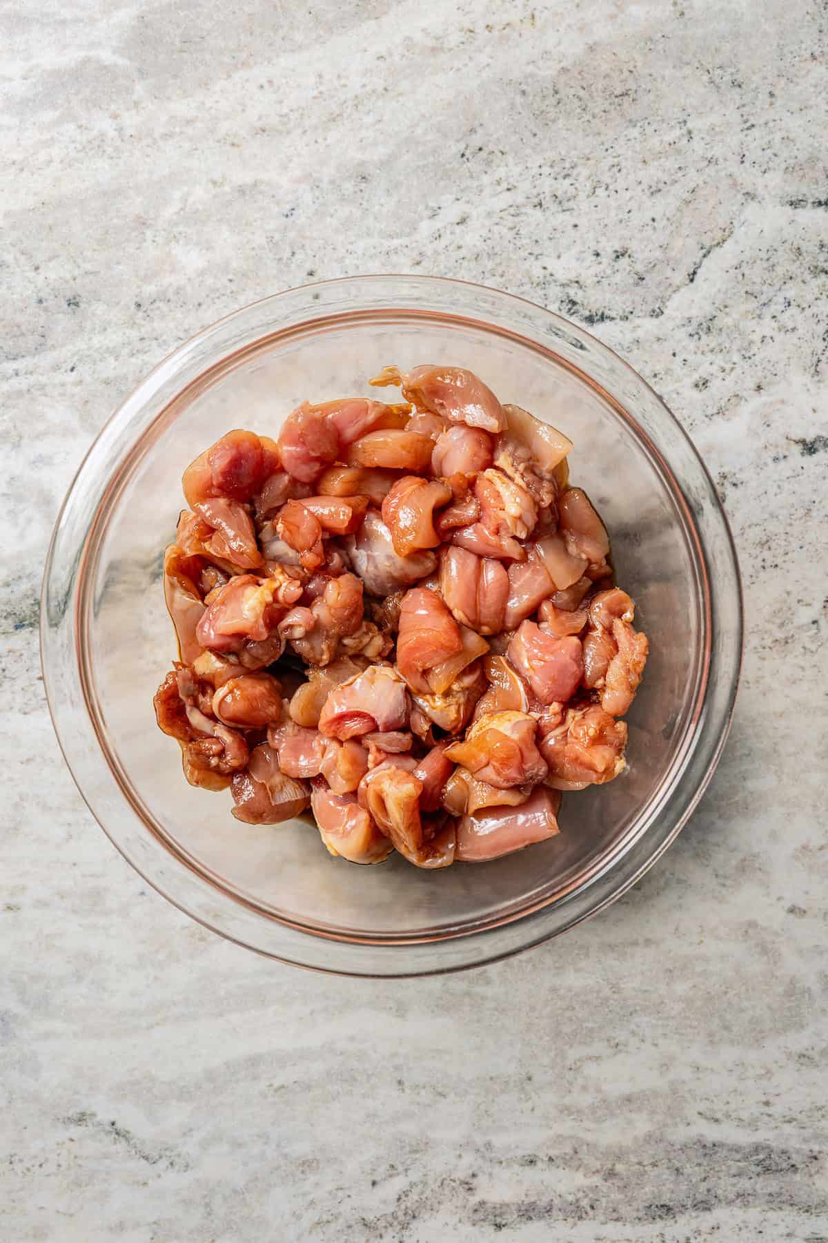 Chicken pieces in a glass bowl.