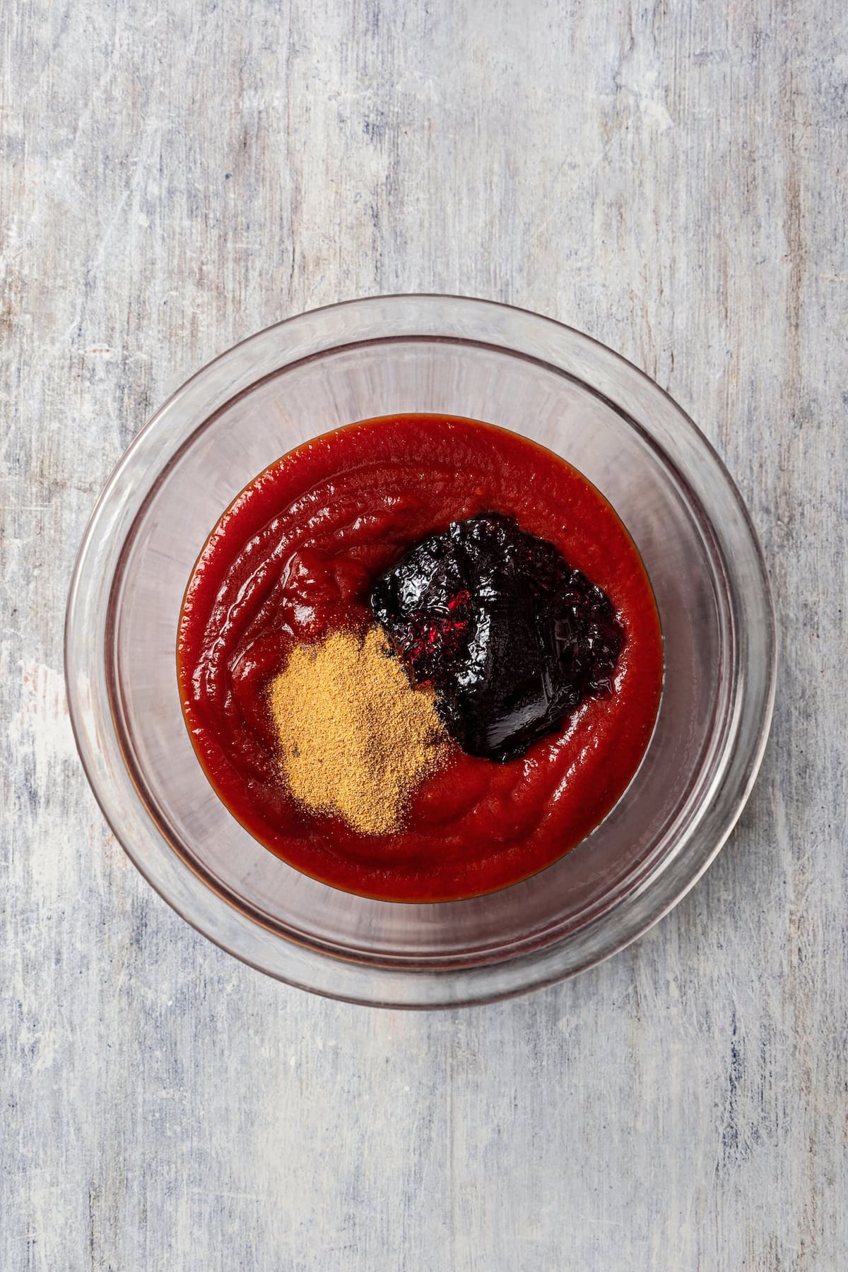 Grape jelly sauce ingredients combined in a glass bowl.