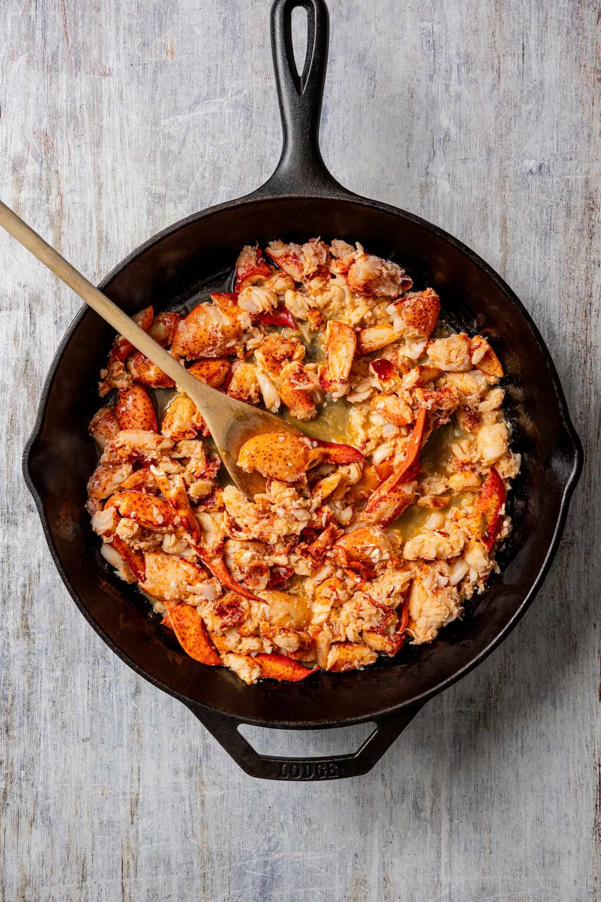 Cooked lobster mixture in a cast iron skillet.