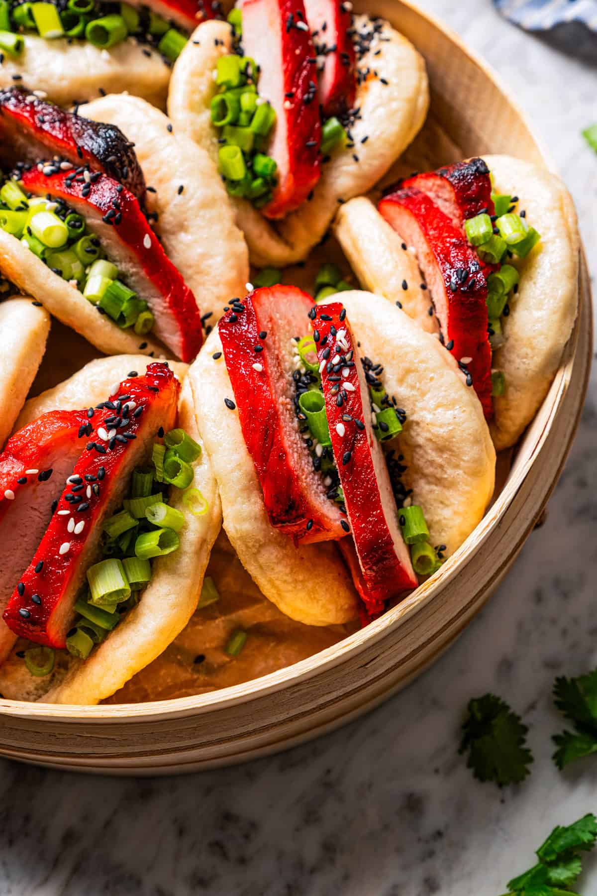 Close up of char siu bao in a steamer basket.