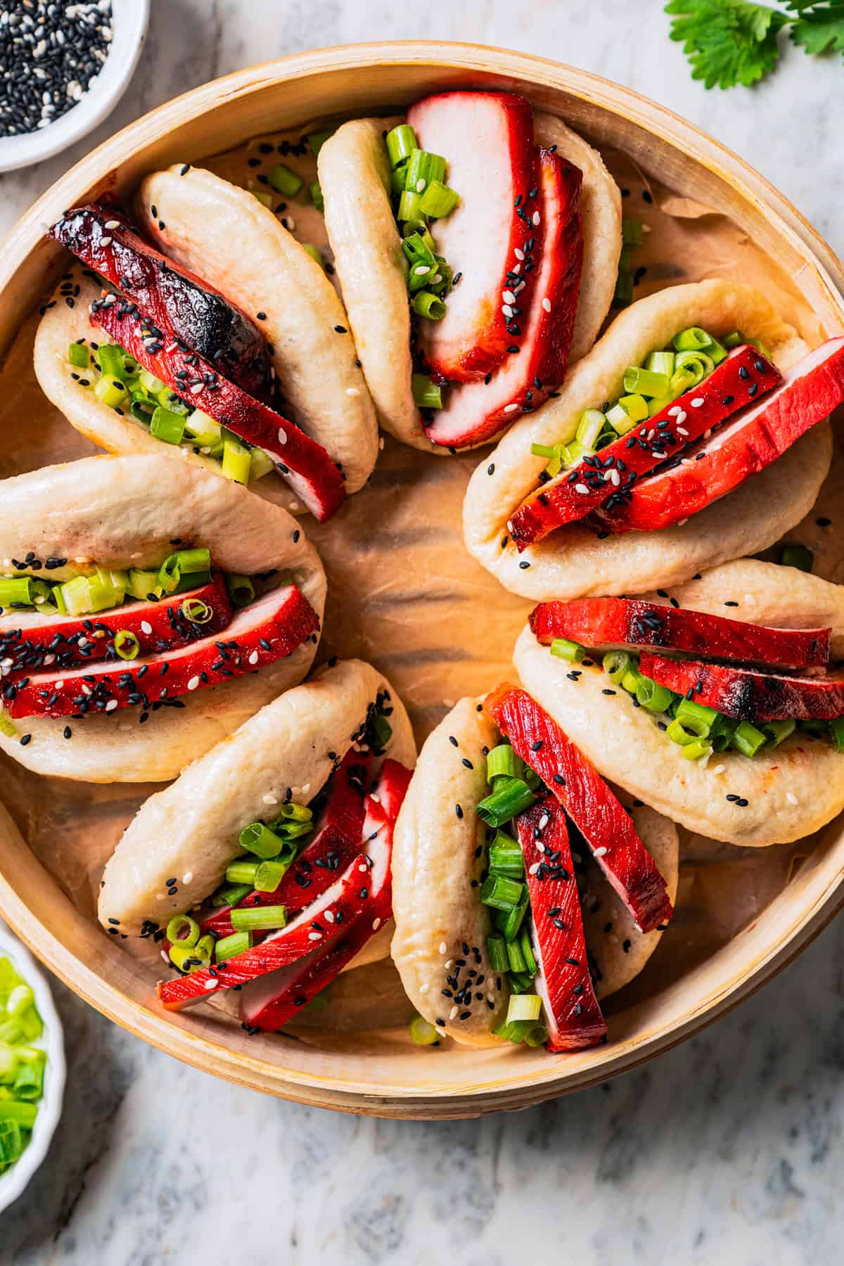 Overhead view of char siu bao buns in a steamer basket.