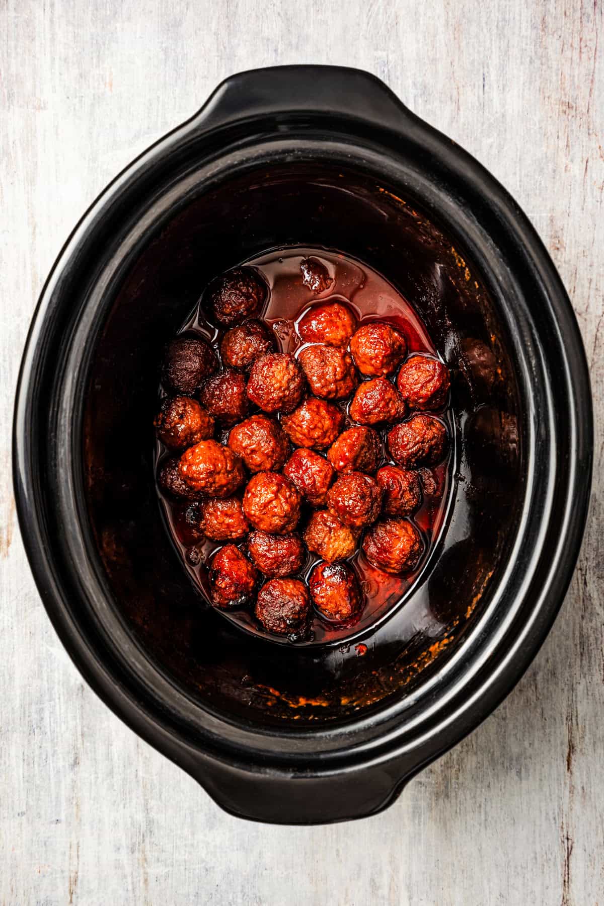 Cooked grape jelly meatballs in a crock pot.