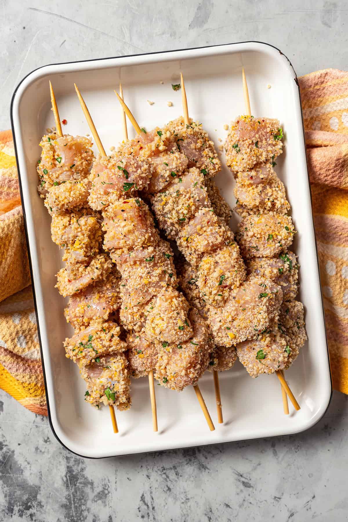 Prepared chicken spiedini skewers on a metal tray, ready to grill.