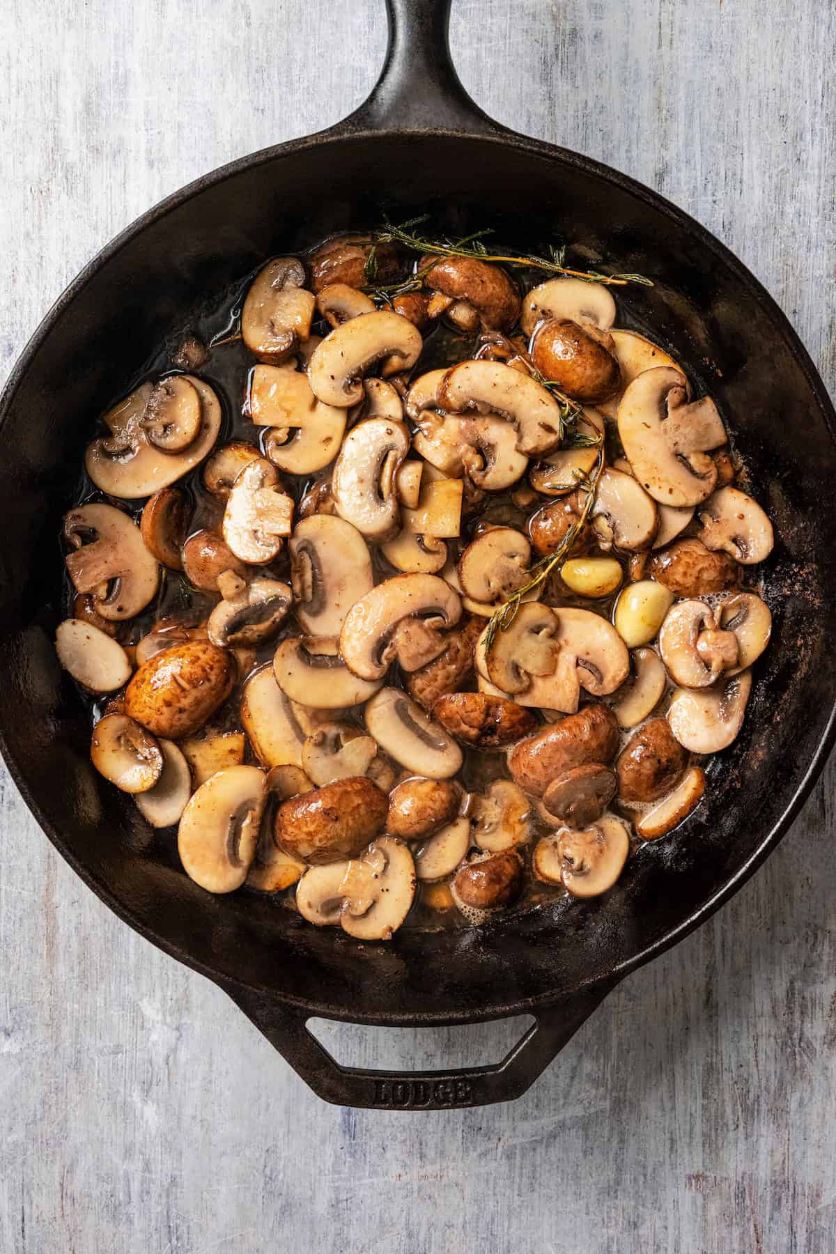 Cooked cremini mushrooms in a skillet.