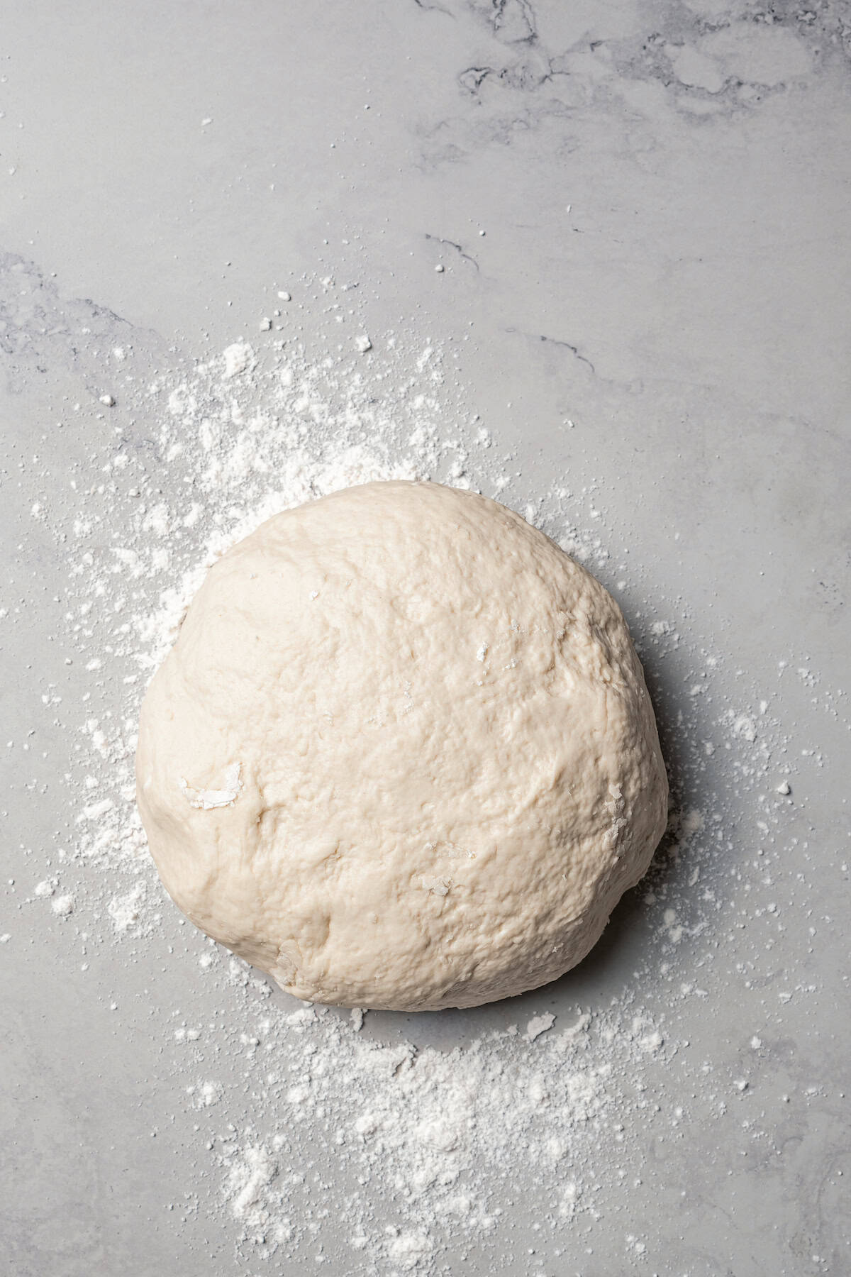 Bagel dough turned out on a floured surface.