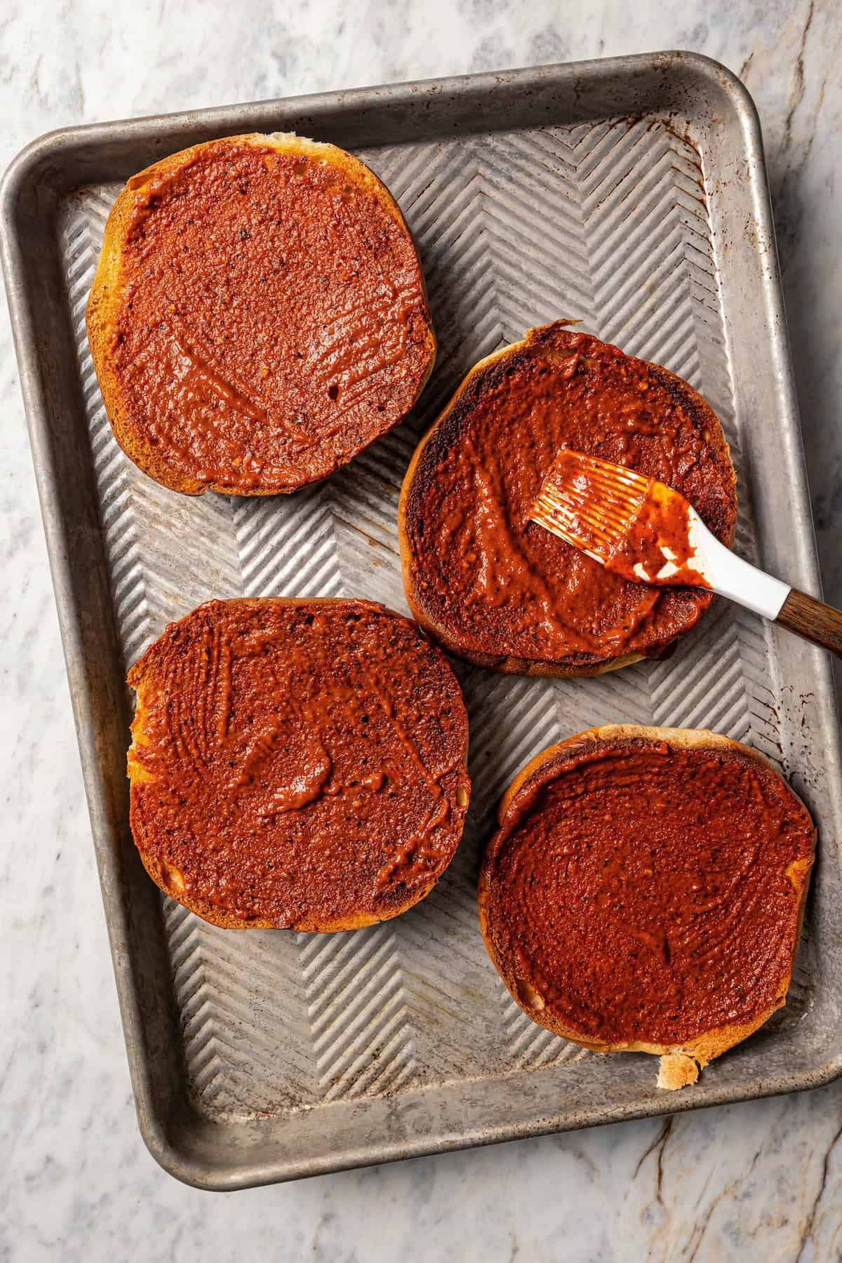 Brushing bread with chili sauce.