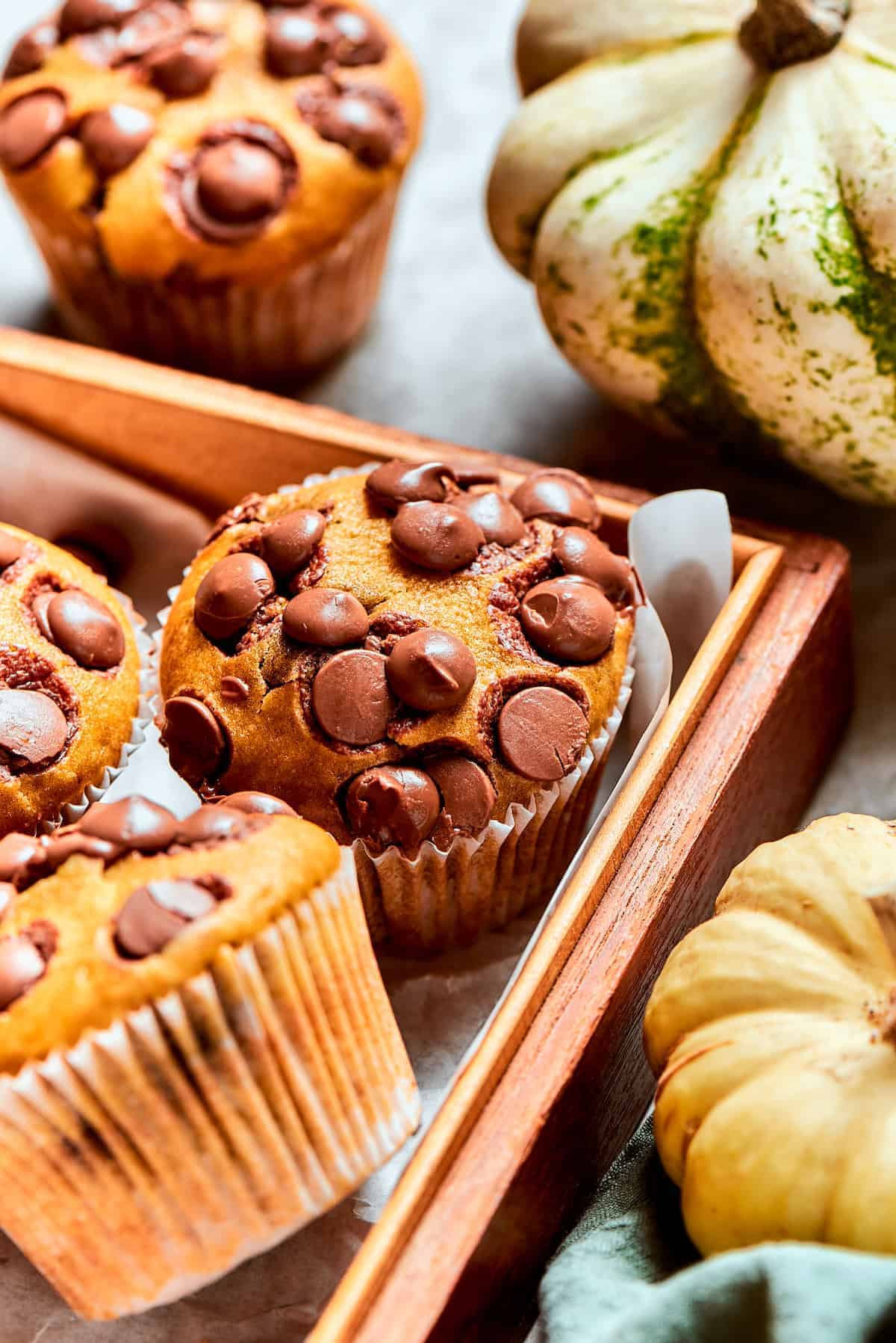 Pumpkin muffins studded with chocolate chips and arranged in a basket.