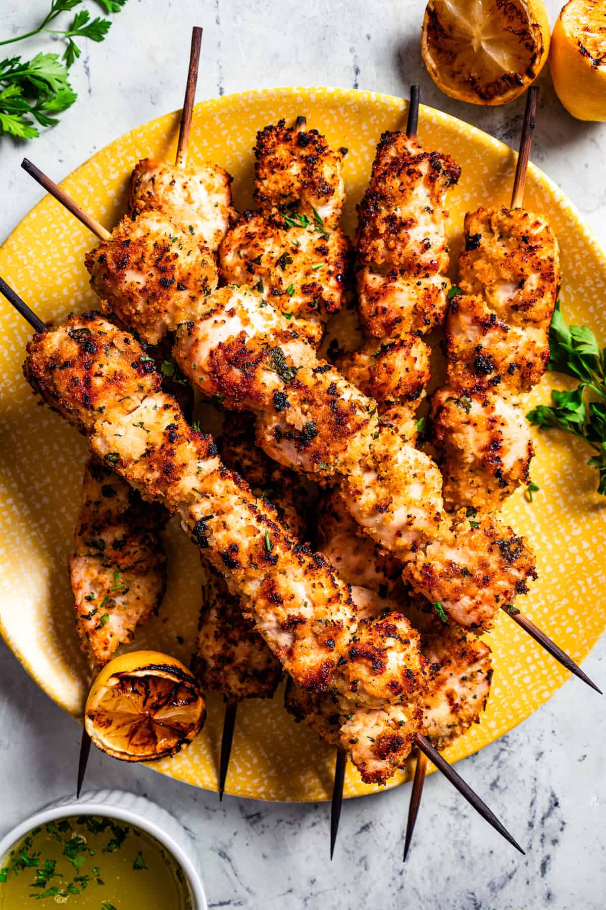 Chicken spiedini skewers arranged on a yellow plate.