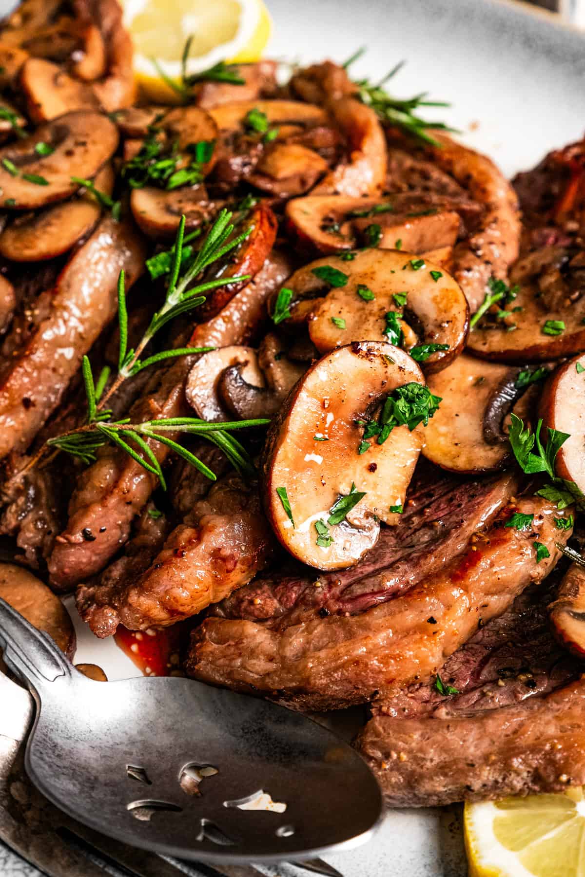 Close-up photo of Coulotte steak topped with mushroom sauce.