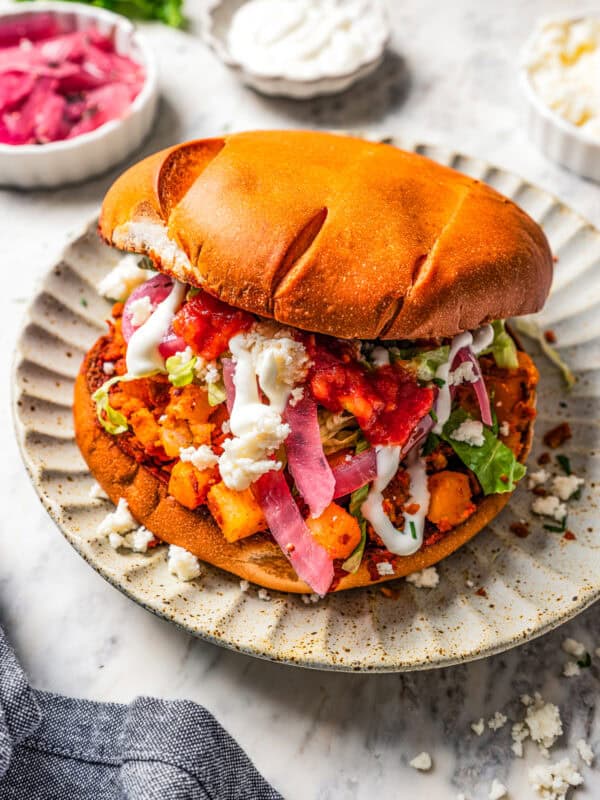 Pambazos sandwich served on a dinner plate.