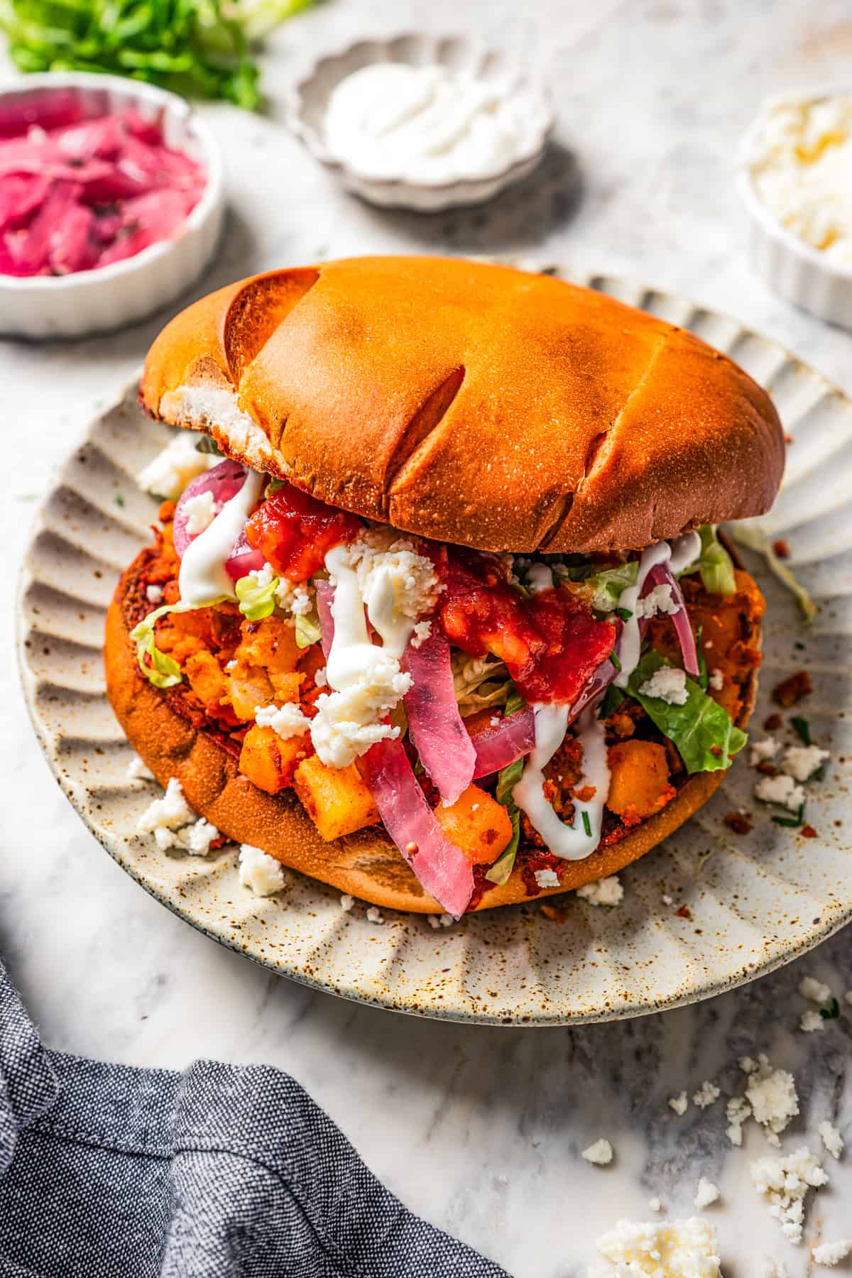 Pambazos sandwich served on a dinner plate.