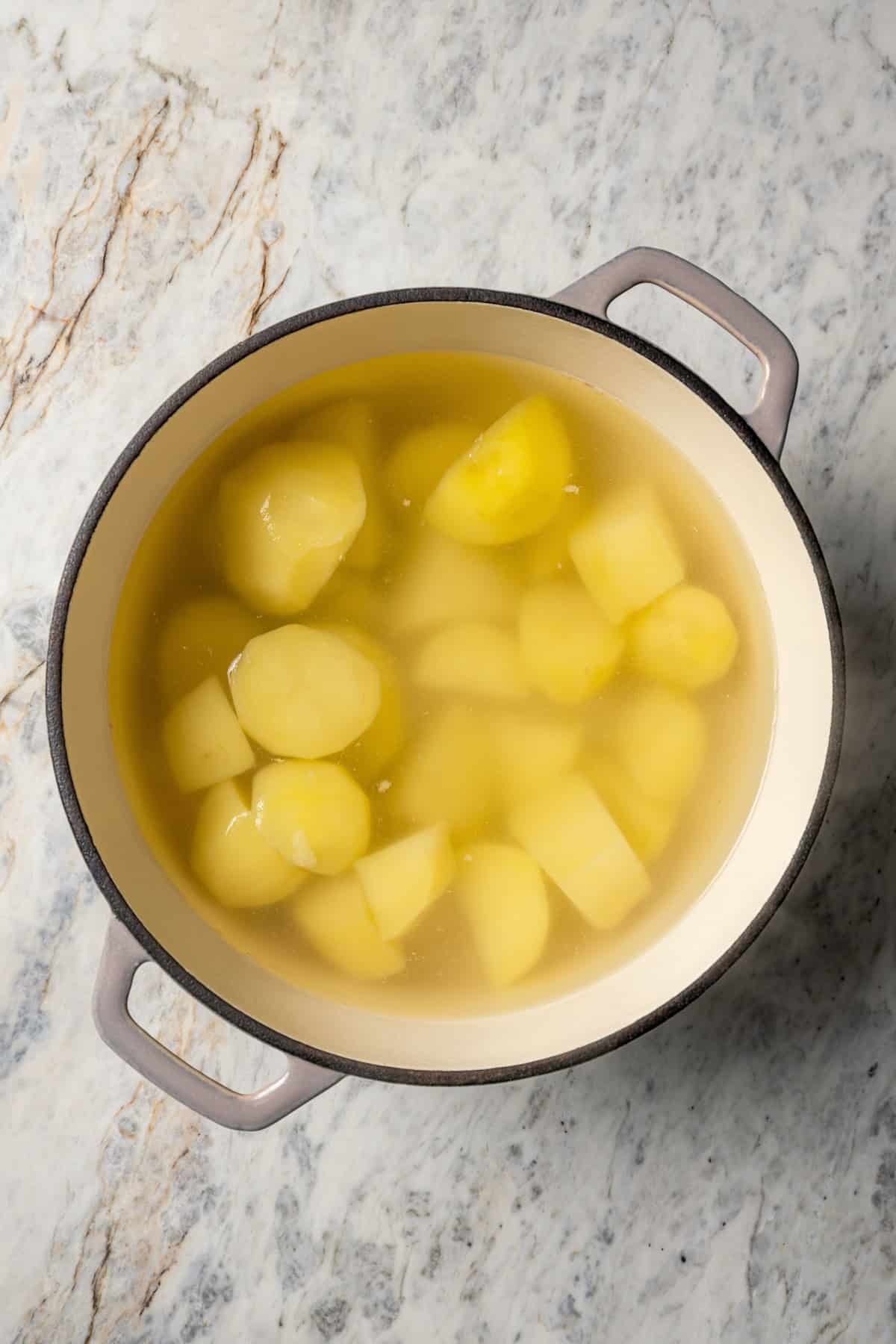 Boiling chopped potatoes.