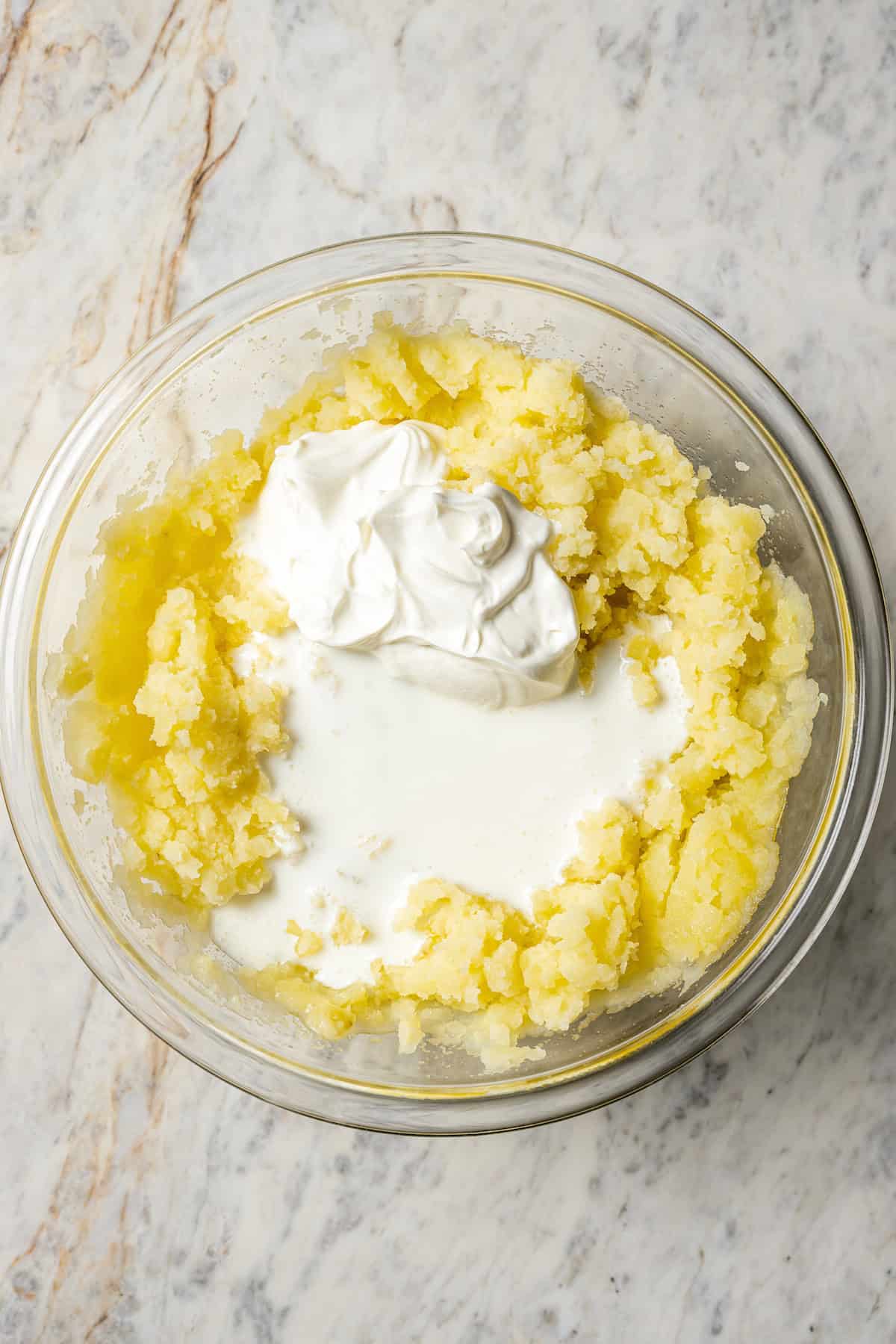 Adding sour cream and buttermilk to mashed potatoes. 