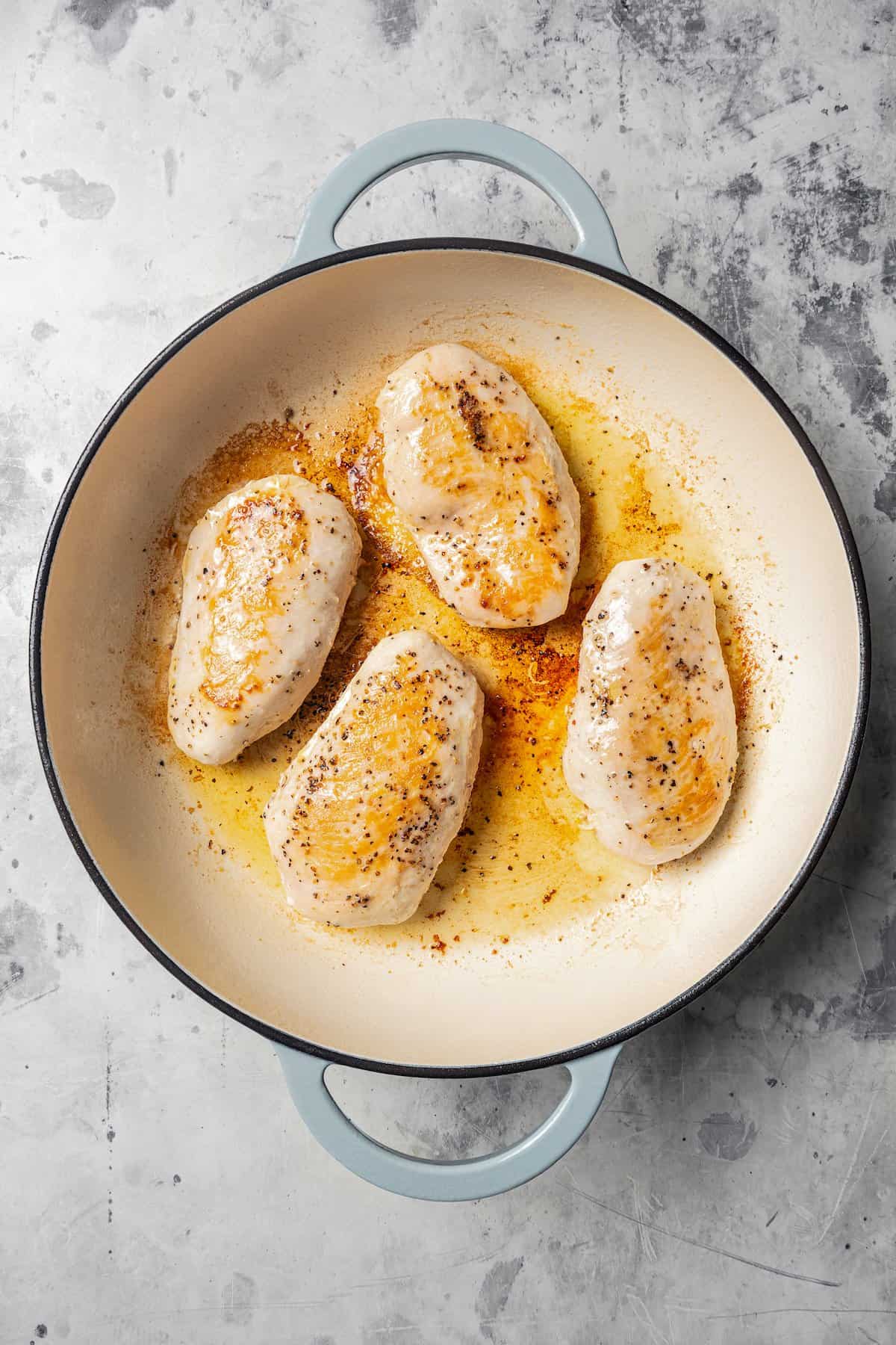 Cooked chicken breasts in a pan.