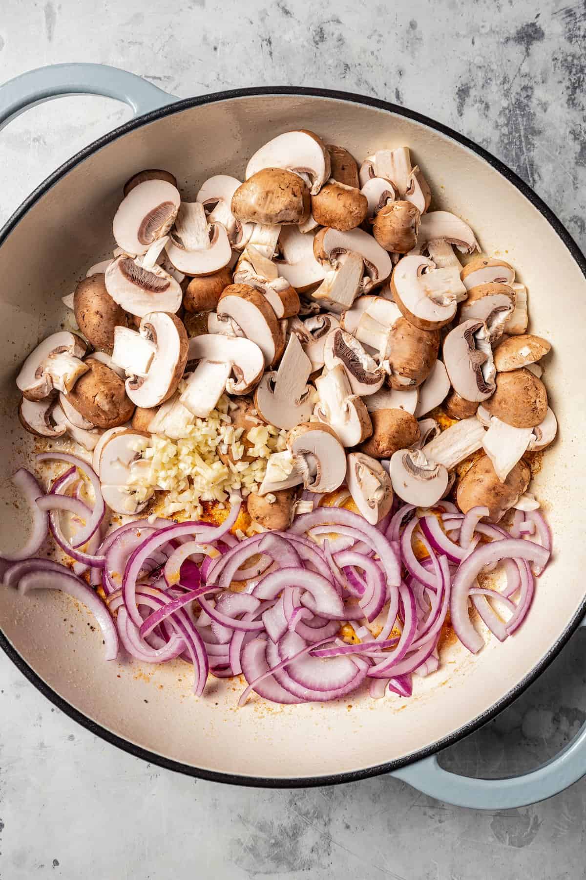 Mushrooms and onions in a pan with garlic.