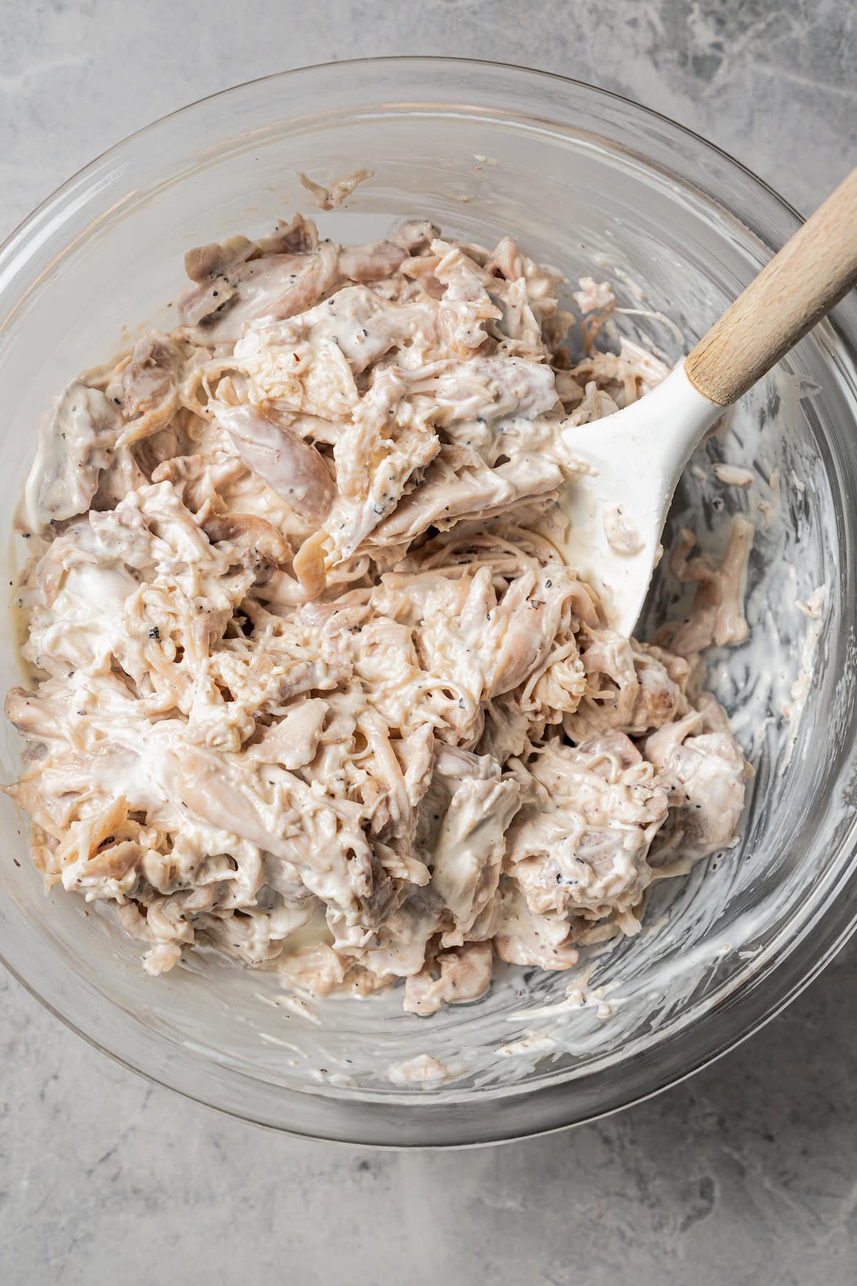 Shredded chicken and mayo in a bowl.