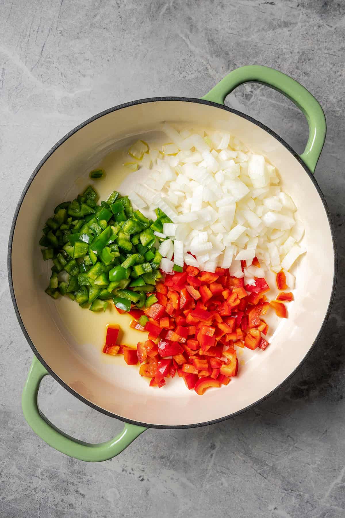 Cooking onions and peppers in a pot.