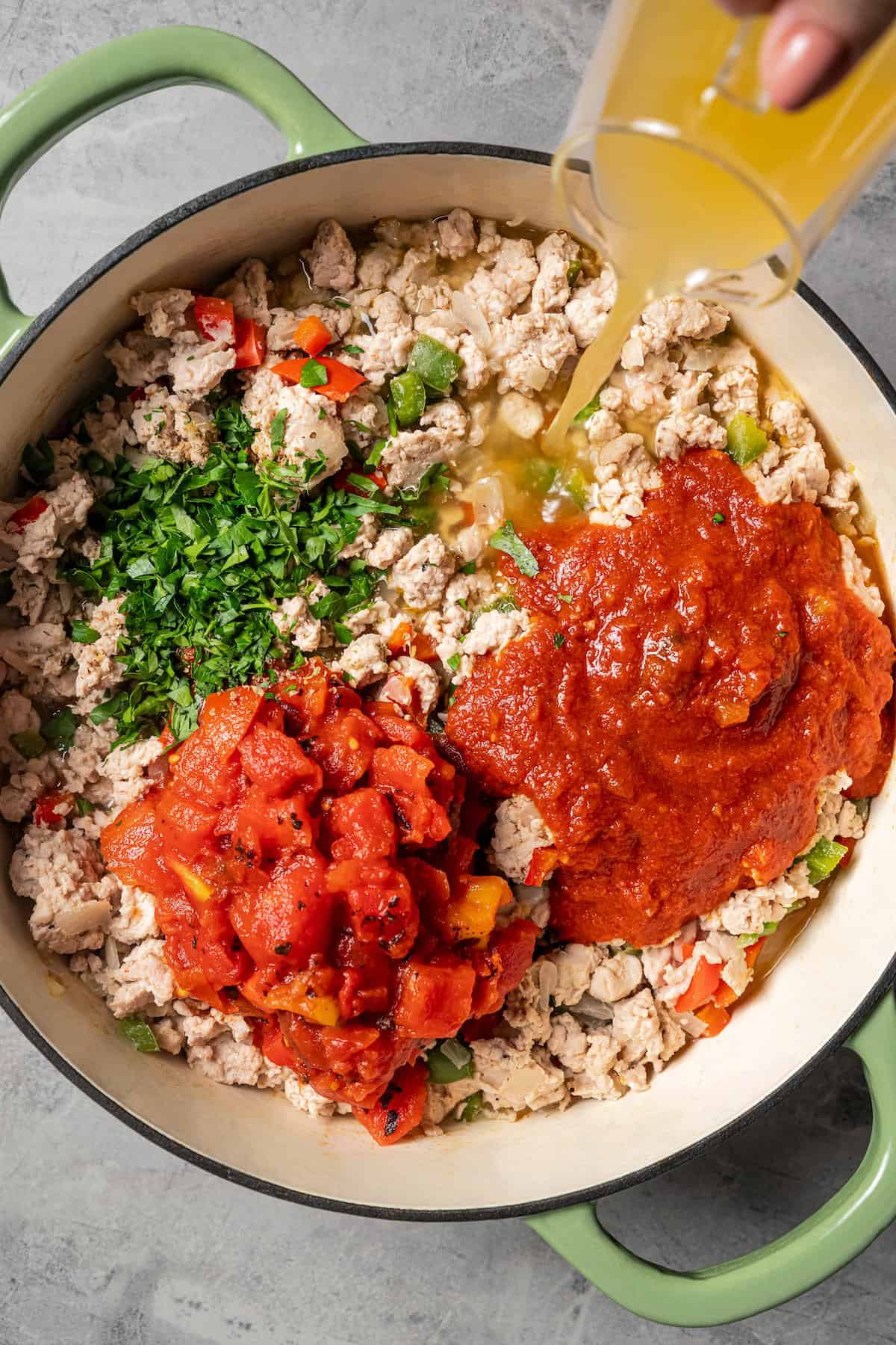 Adding tomatoes to the pot.