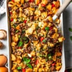 Overhead view of a serving of breakfast casserole being lifted from a baking dish.