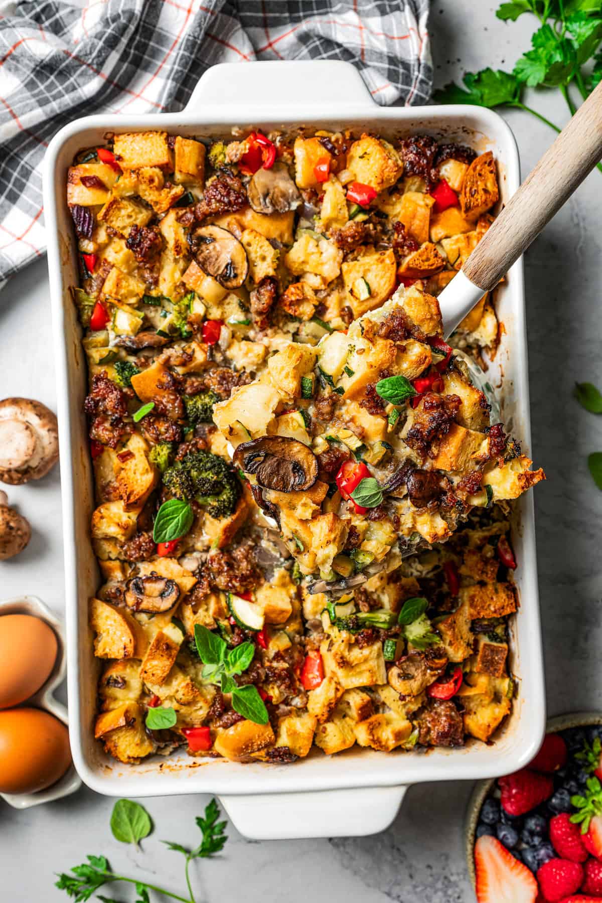 Overhead view of a serving of breakfast casserole being lifted from a baking dish.