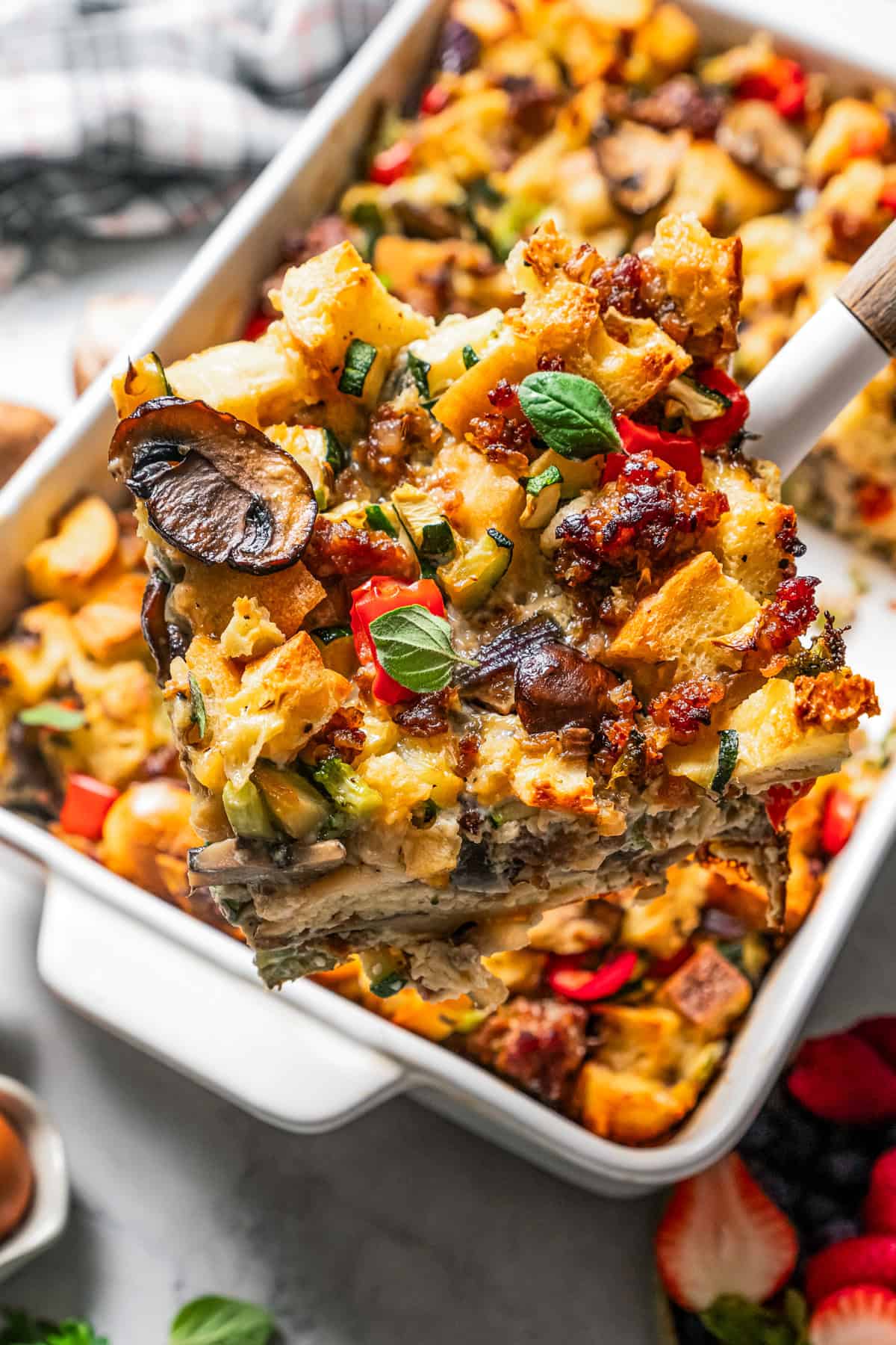 A serving of breakfast casserole is lifted from a baking dish.