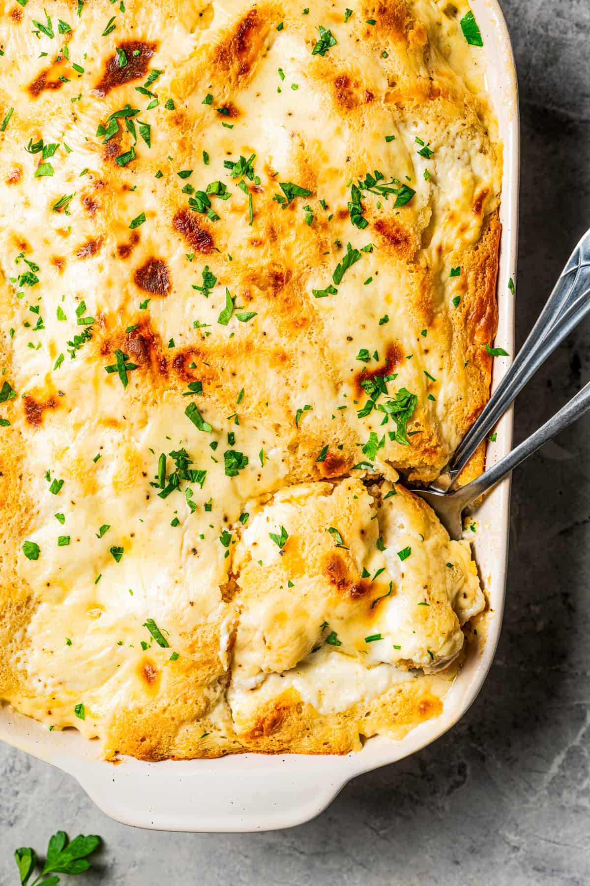 Two spoons resting in a chicken cobbler.