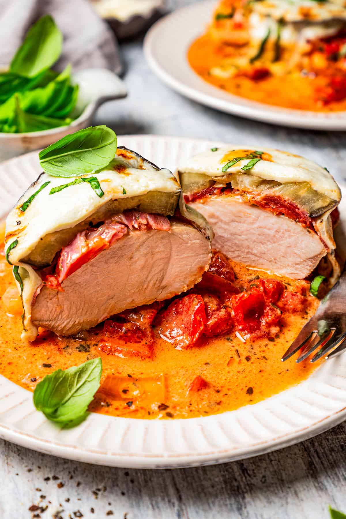 Chicken sorrentino cut in half and served on a plate.