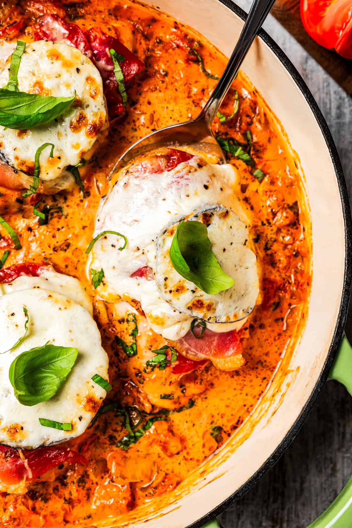 Spoon lifting chicken Sorrentino out of the pan.