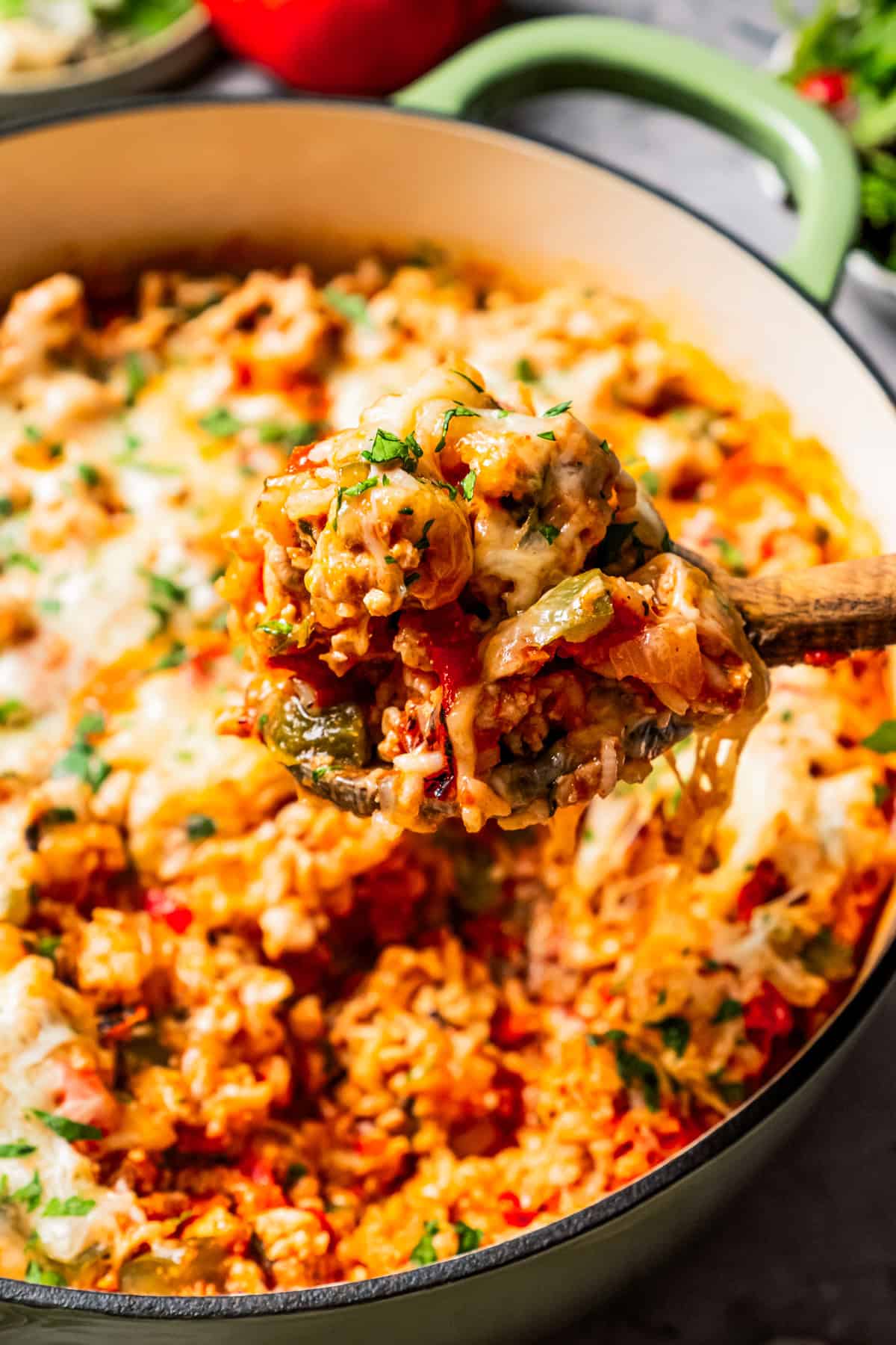 Spooning out stuffed pepper casserole from a pot.