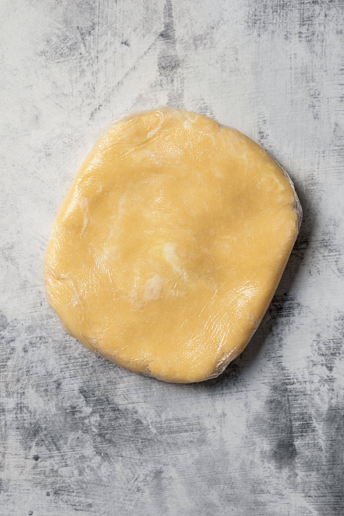 Crust dough shaped into a rectangle on a marble surface.