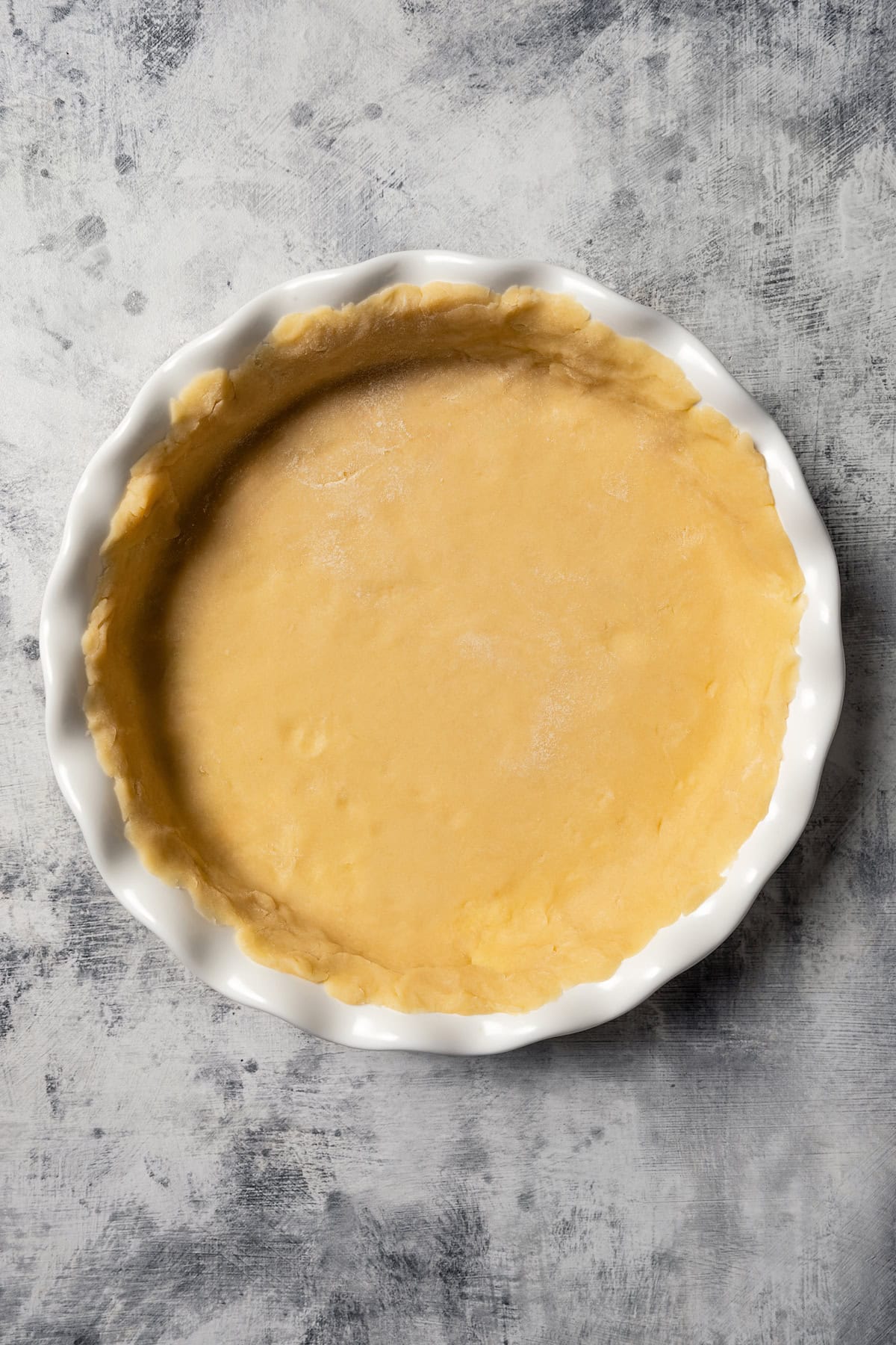 Crust dough pressed into a ceramic pie plate.